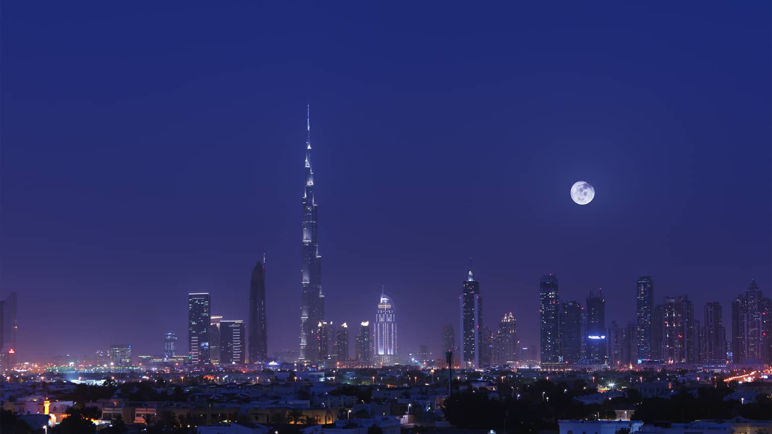 The Dubai skyline as illuminated by a full moon.
