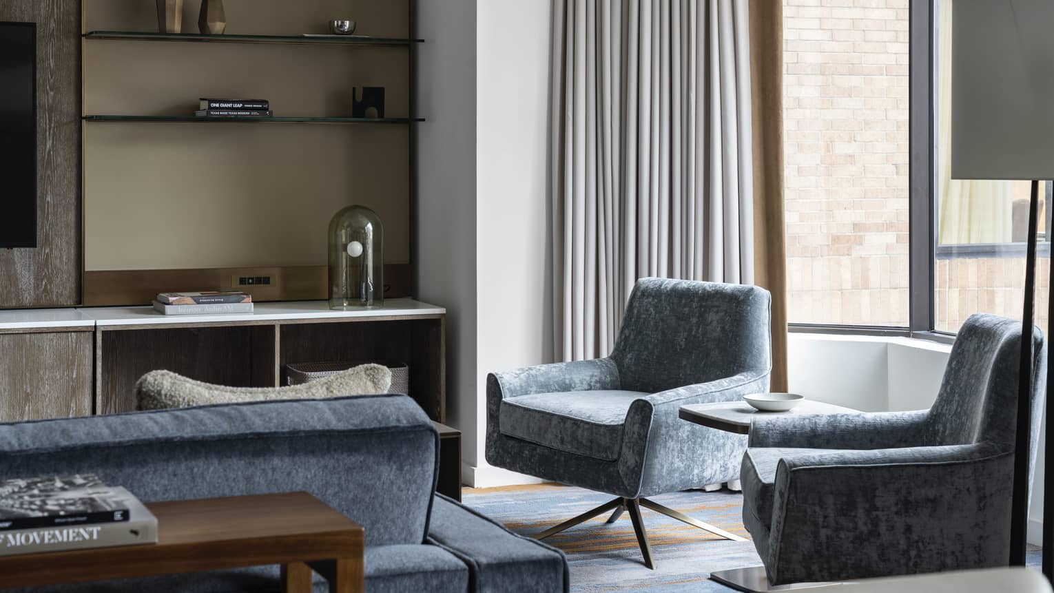 Residence at Four Seasons Hotel Houston, with shelving unit and light-blue chairs and couch near window
