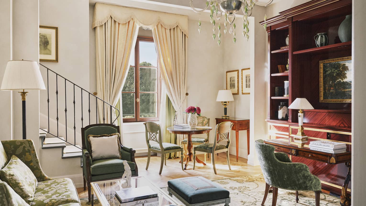 Elegant living room with sofa, chair, desk and small table with three chairs, chandelier and window, Executive Suite at Four Seasons Hotel Florence