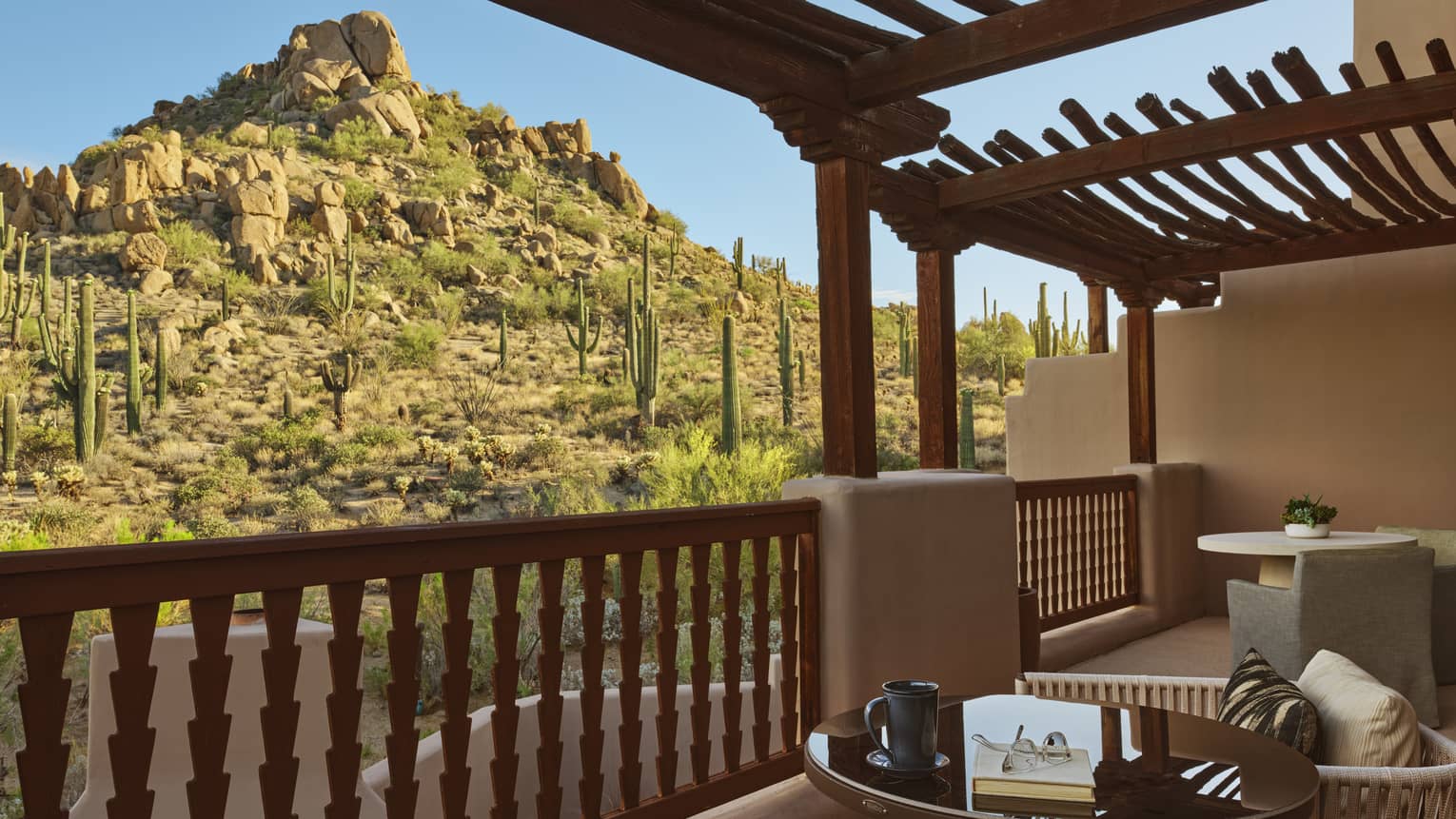 Private terrace with two sets of table and two chairs, with desert mountain view
