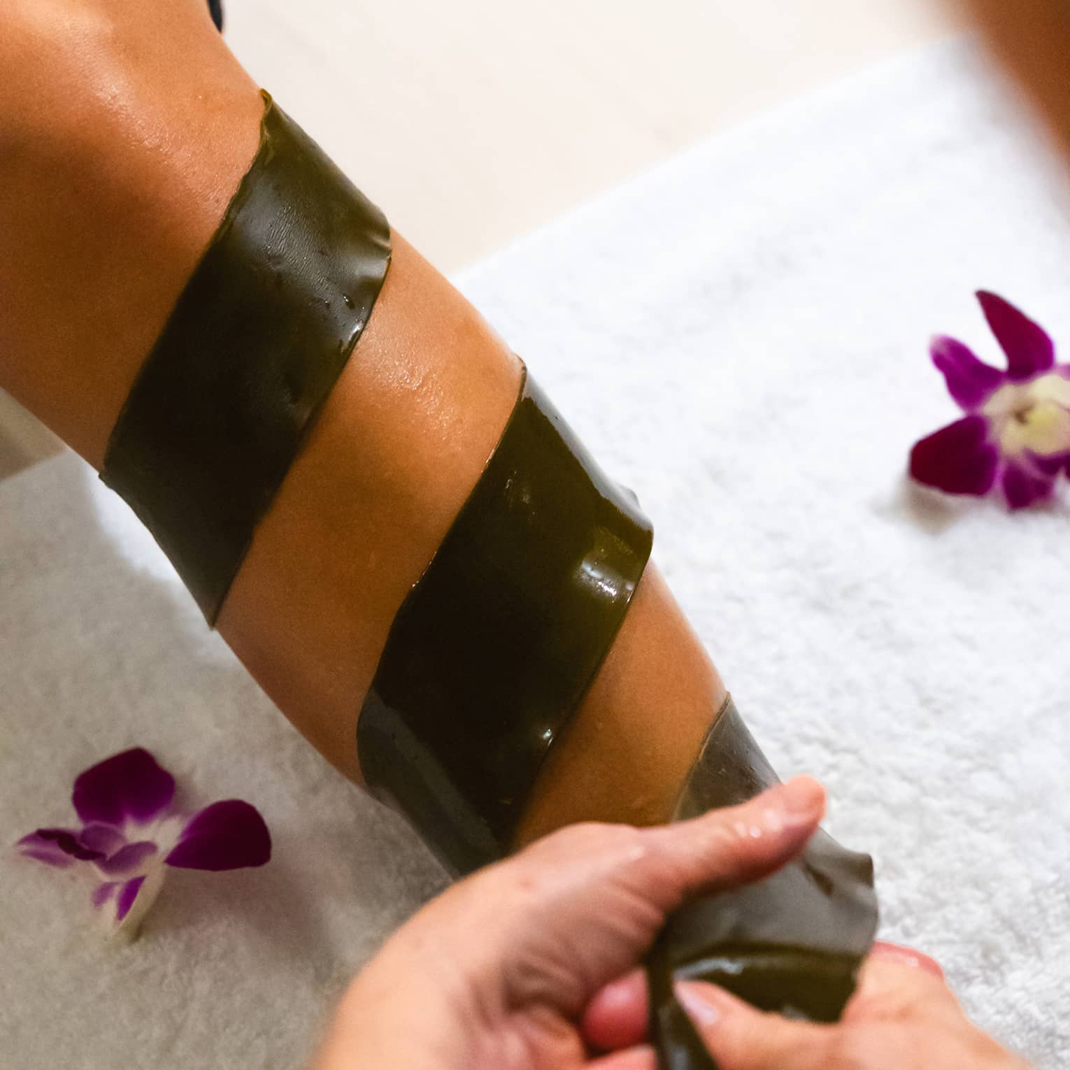 A piece of seaweed is being wrapped around someone's arm