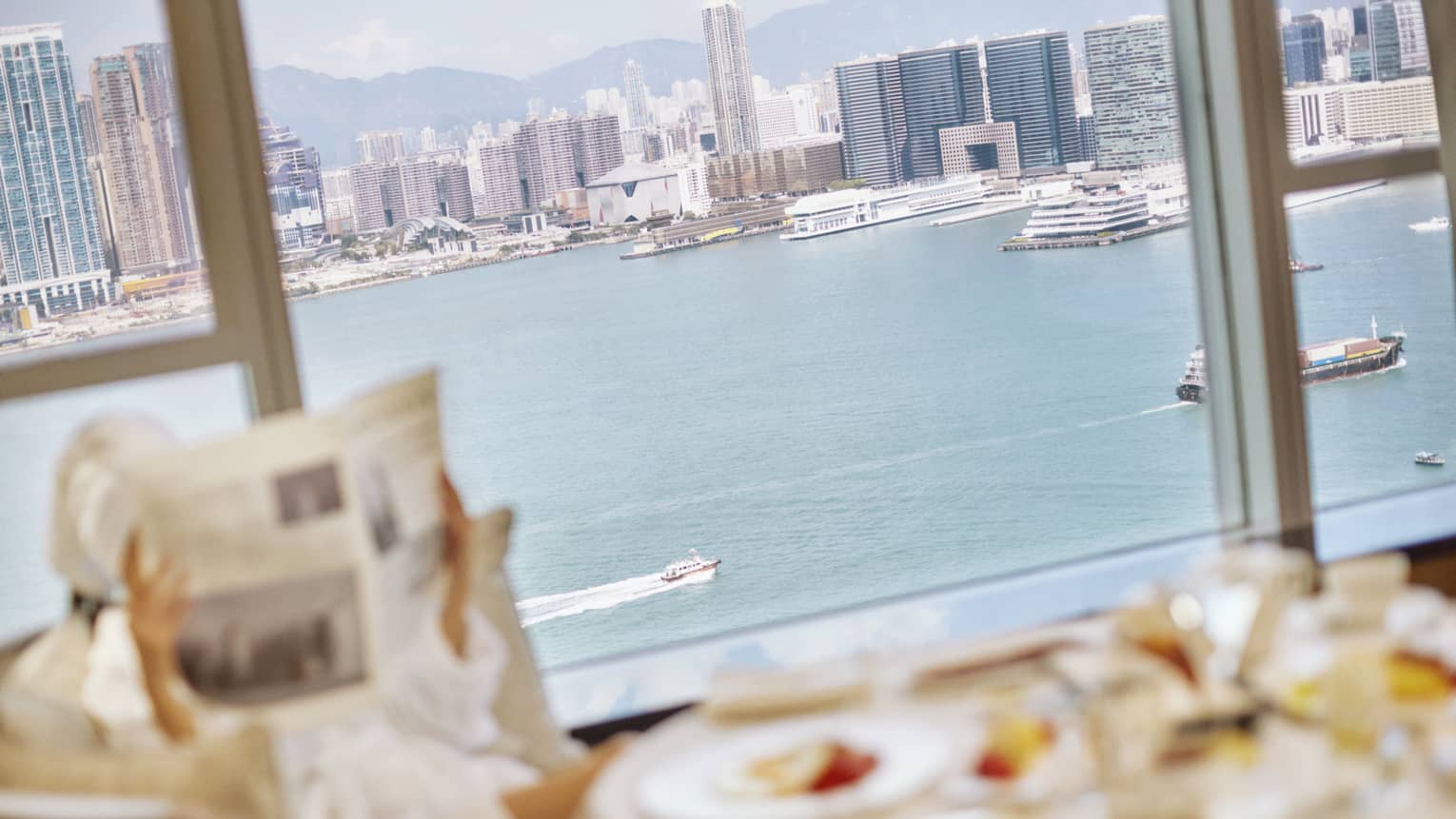 A mother and child are looking out at the city through binoculars
