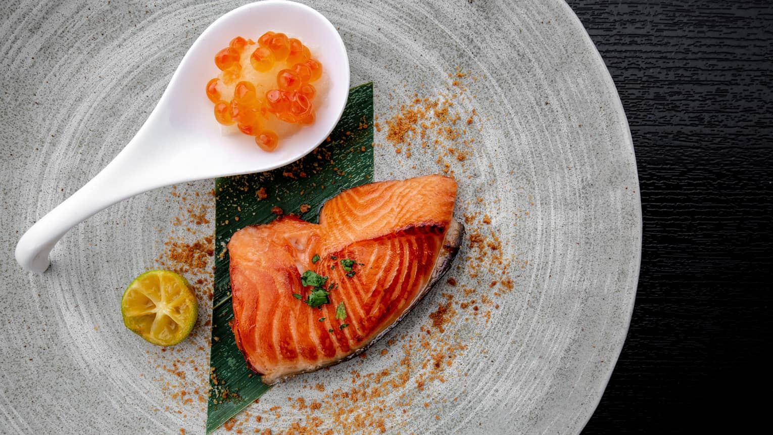 Piece of salmon and roe on a modern grey plate