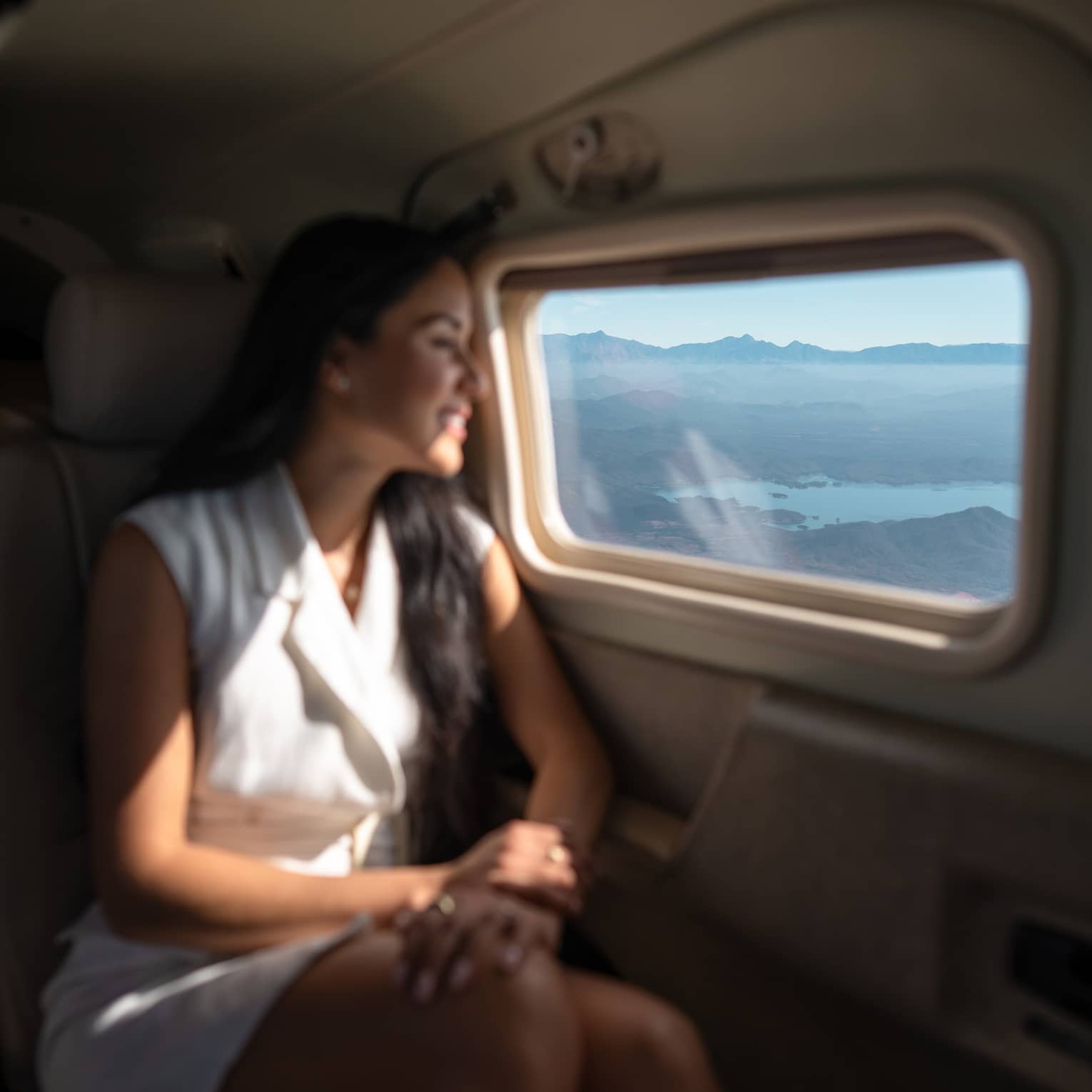 A woman looks out a plane window