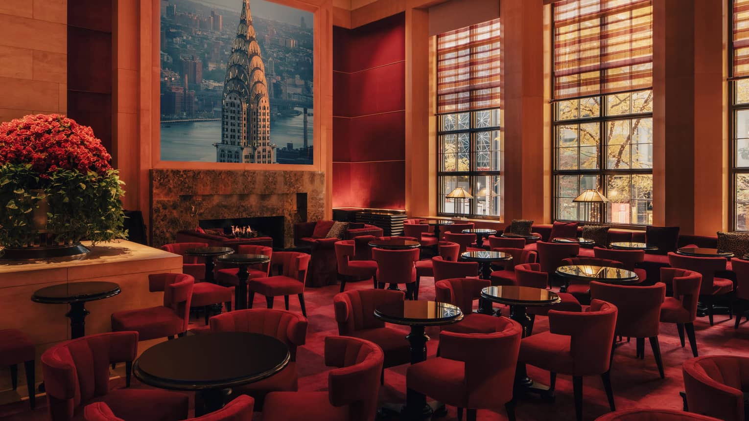 A spacious yet cozy lounge interior with upholstered seating, large windows and artistic decor