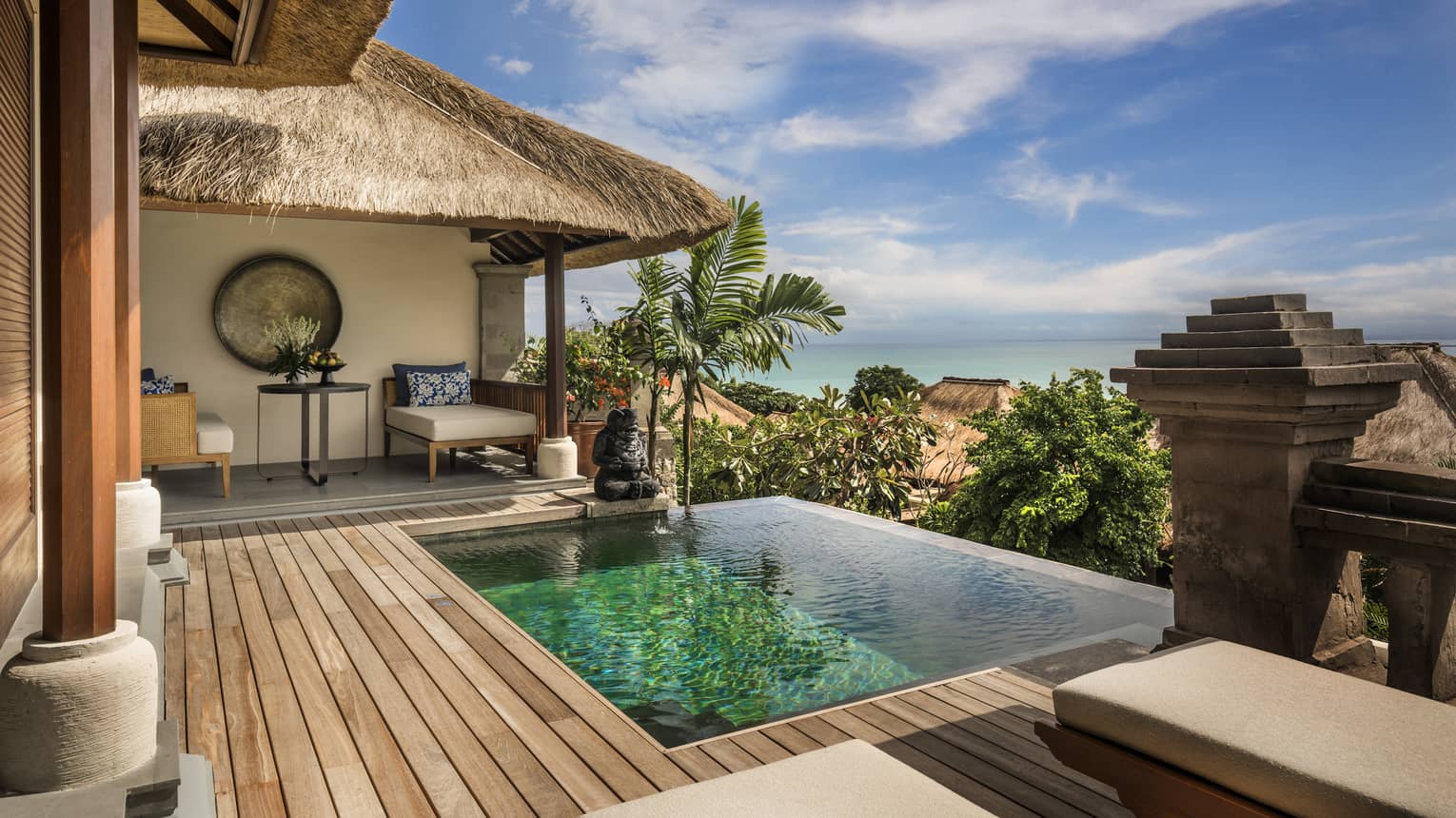 Luxury tropical villa with private pool, ocean view, and thatched roof patio.