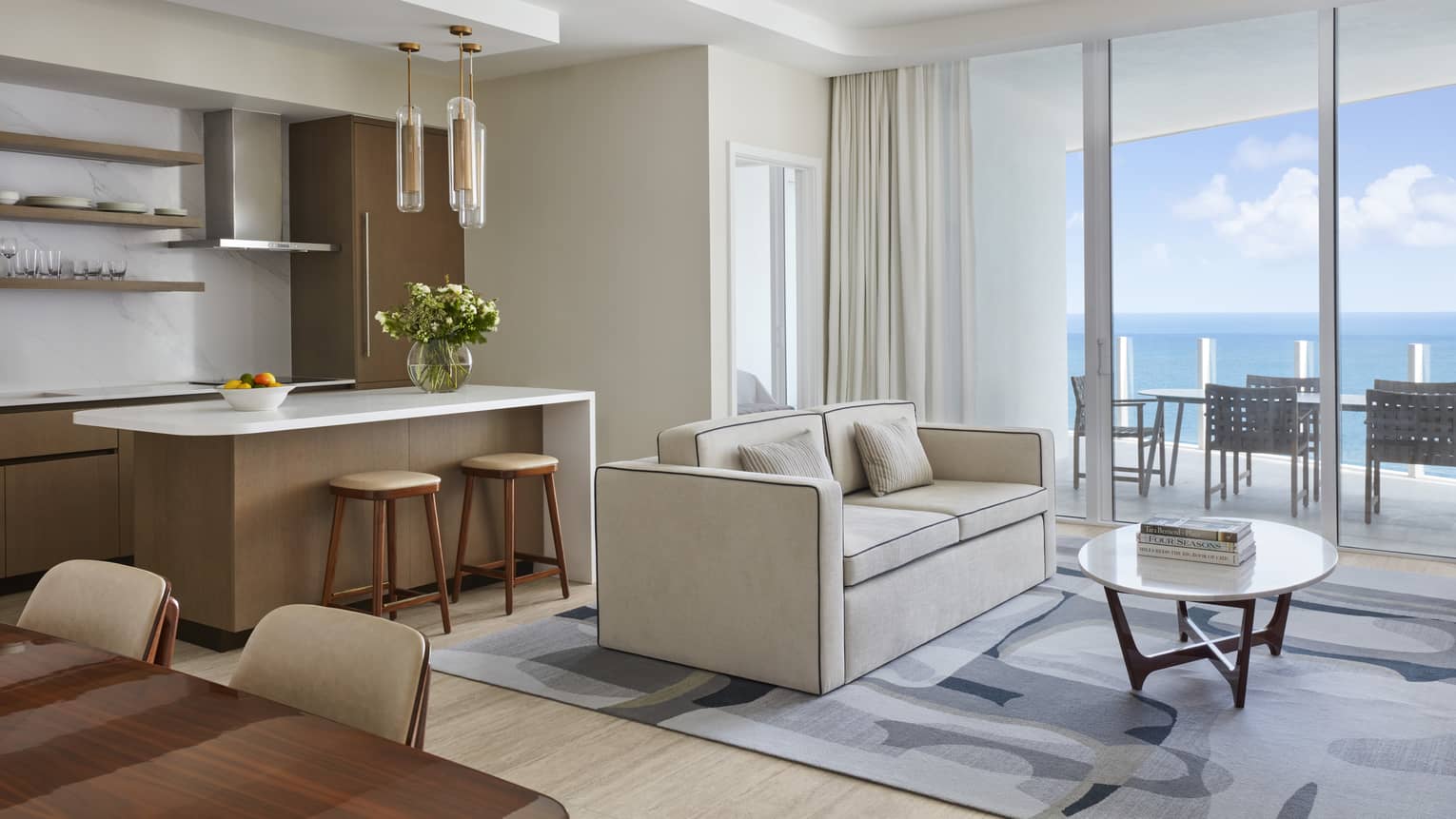 Light-filled living room and kitchen island with ocean view