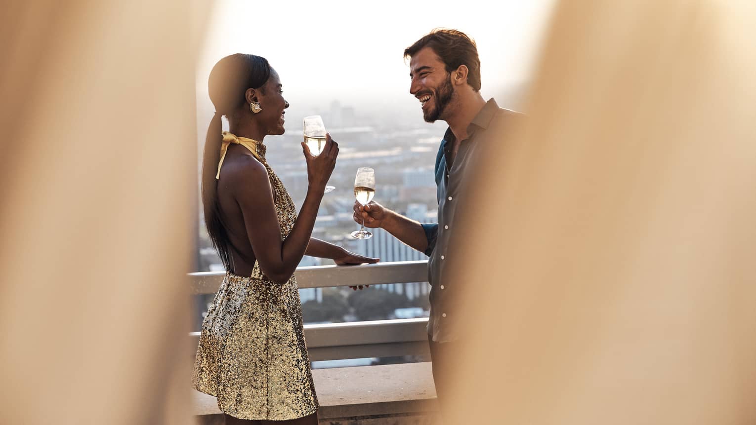 A man and woman with wine on a balcony.