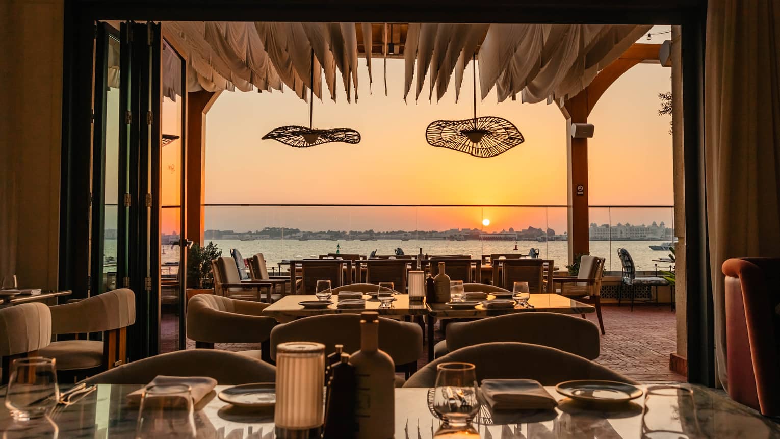 Restaurant dining room that opens up onto a waterfront terrace