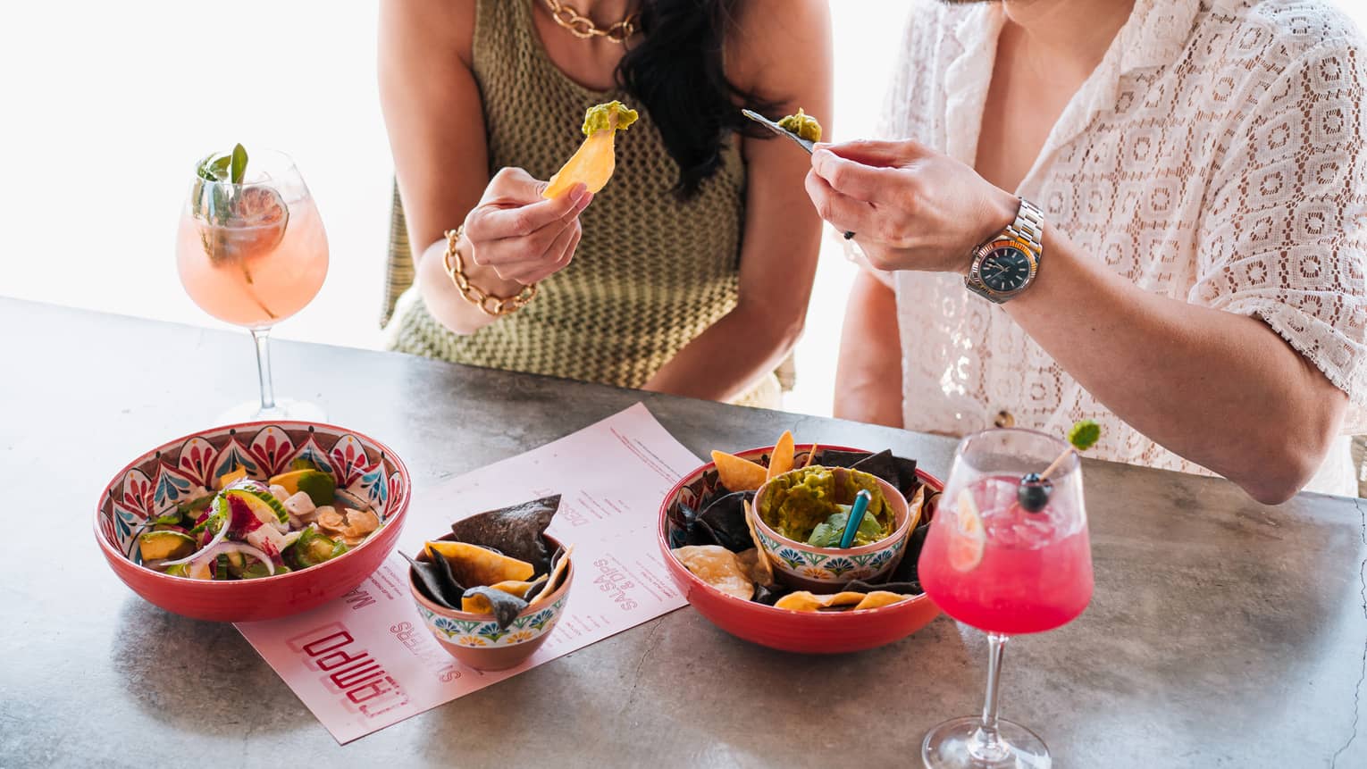 A couple enjoys colourful dishes and cocktails outdoors