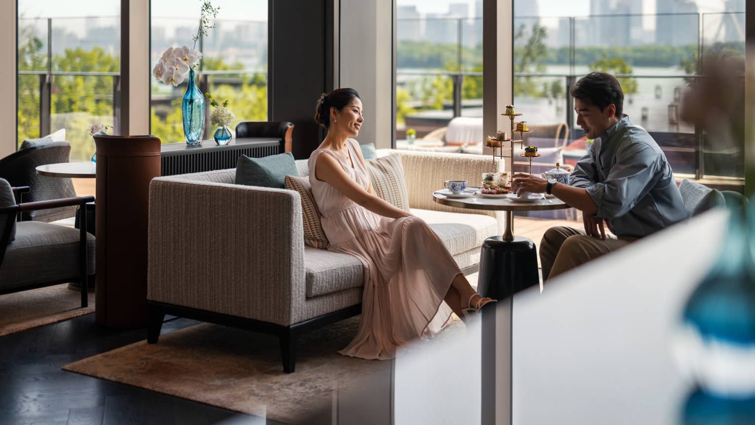 Man and woman enjoy afternoon tea at Lobby Lounge at luxury hotel