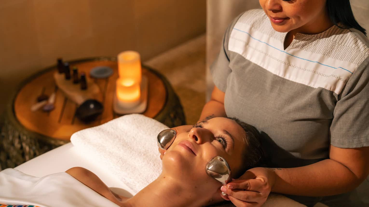 Facialist places two silver nodes on a clients face