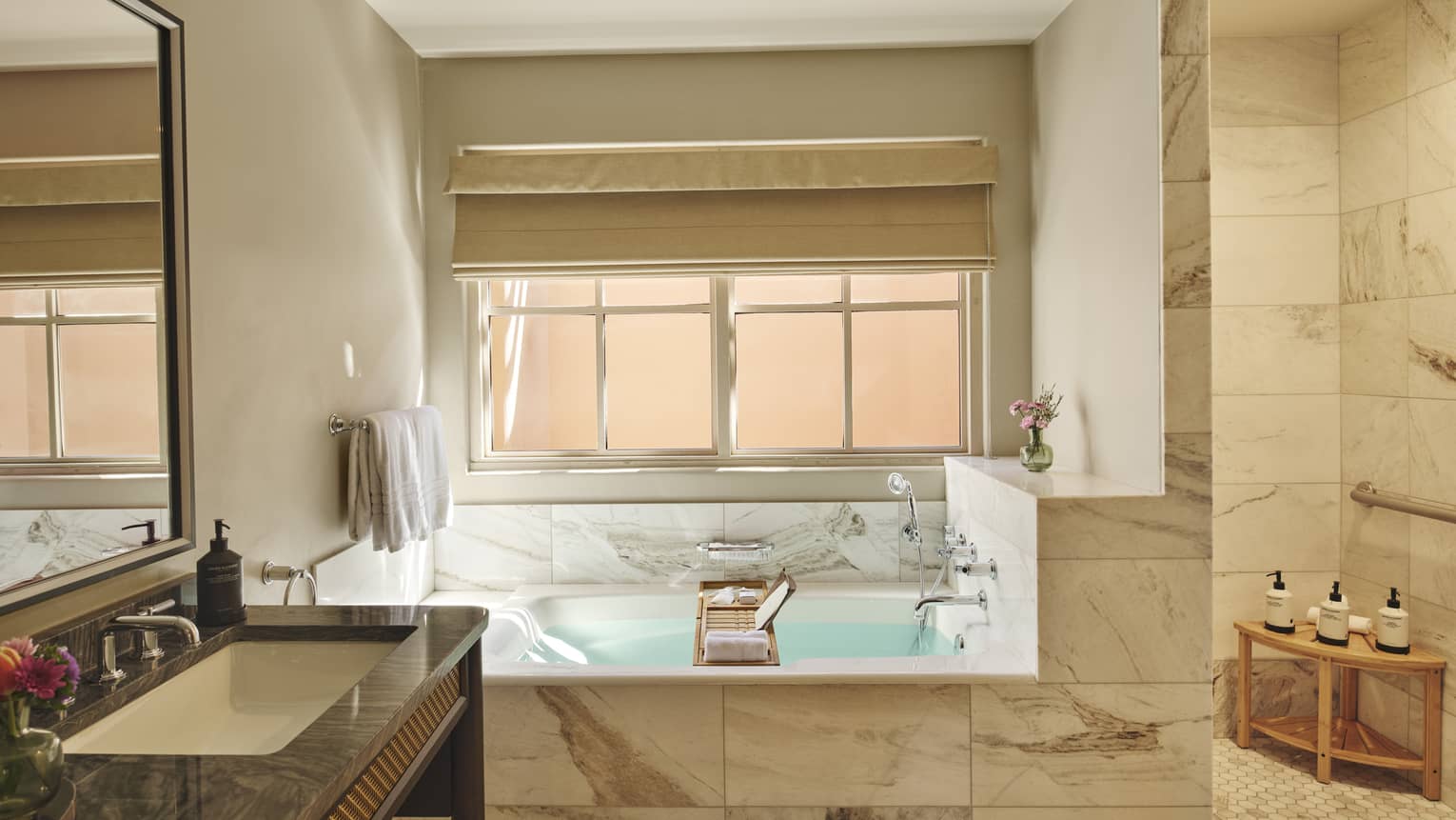 Mobility accessible marble bathroom with separate tub and roll-in shower