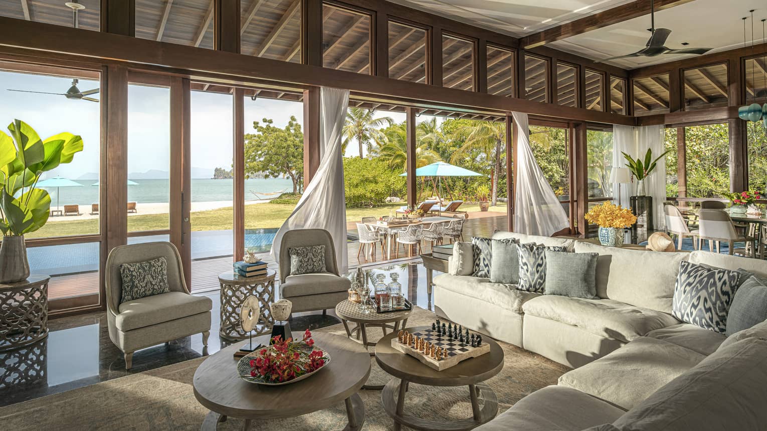 Large indoor-outdoor living room, opening up to beach view and pool terrace