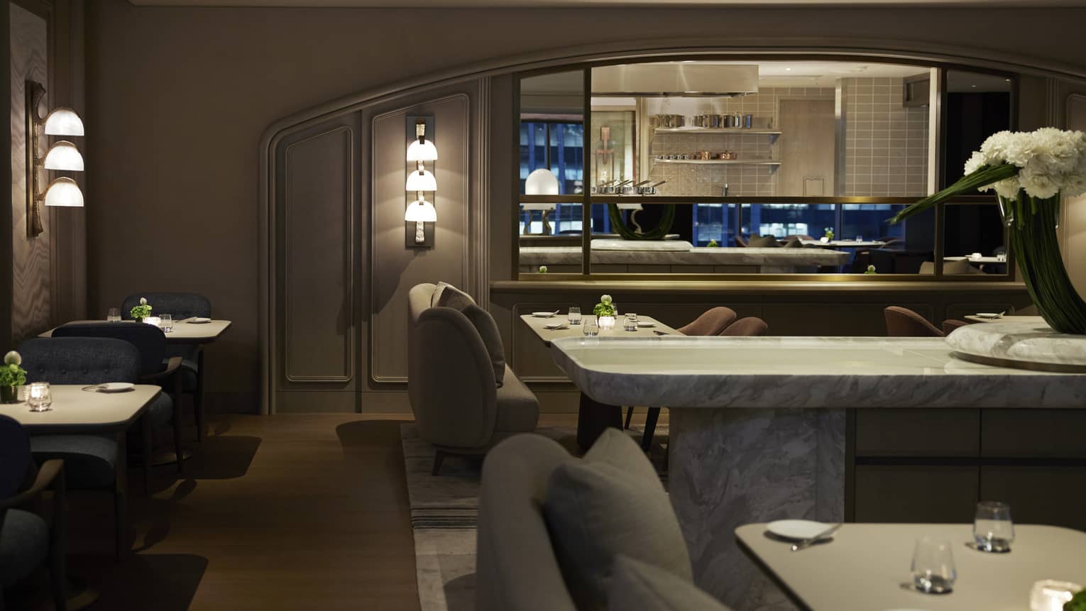 Dining room at S�ZANNE intimately lit, show kitchen visible in background