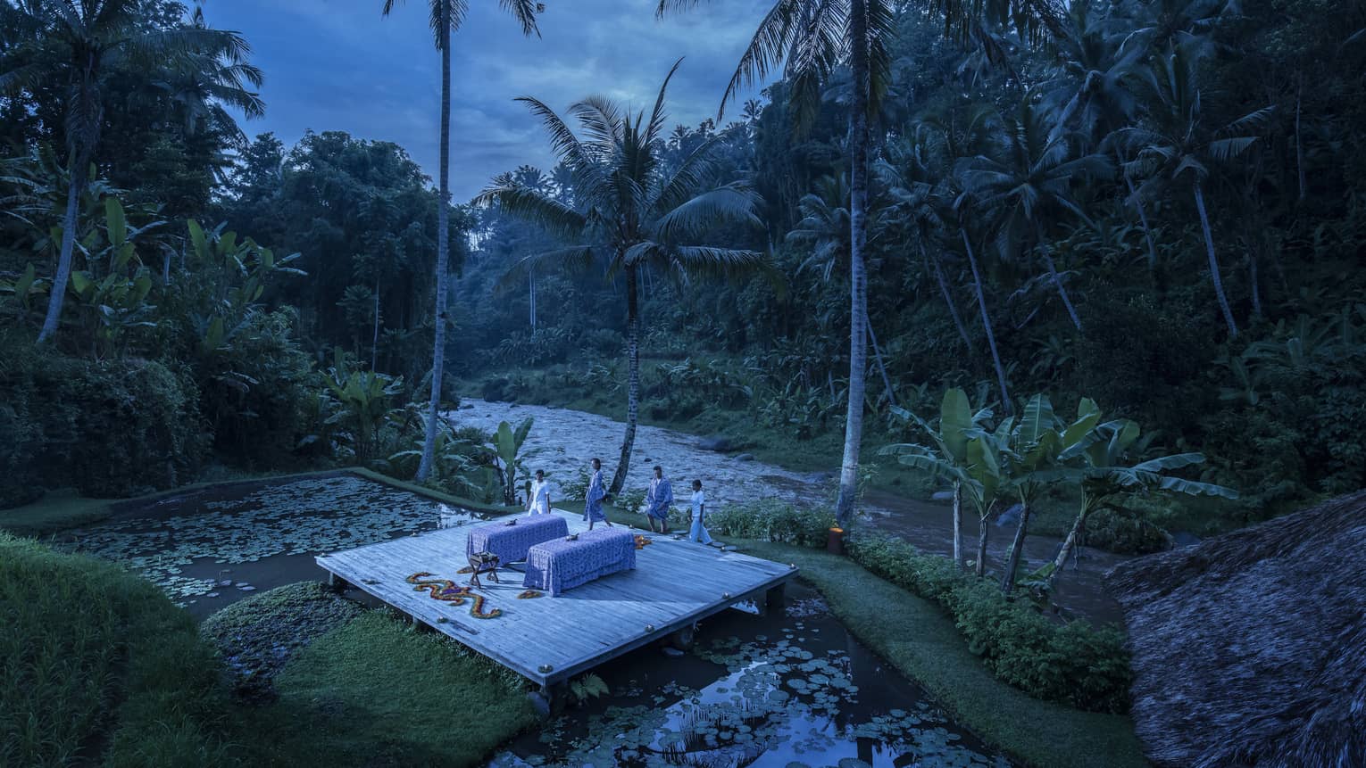 A few wellness experts preparing for a private outdoor treatment at dawn