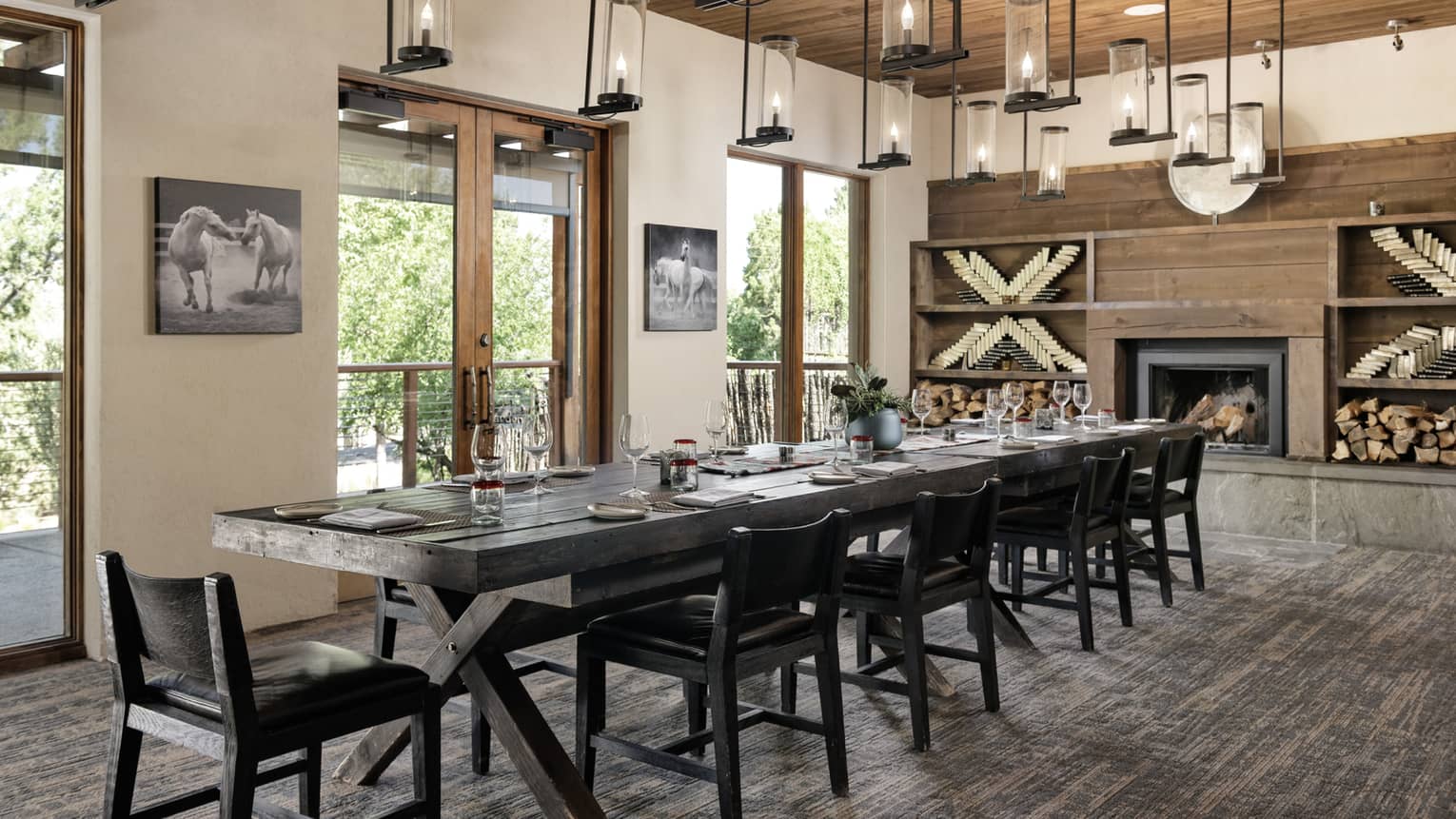Dining room with hanging lights, a fireplace, a rectangular table and chairs.