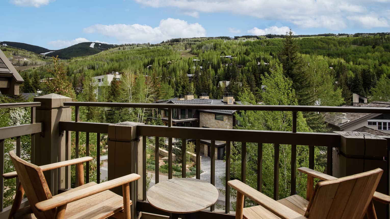 Balcony with two wooden chairs, small wooden table, and views of Vail Mountain