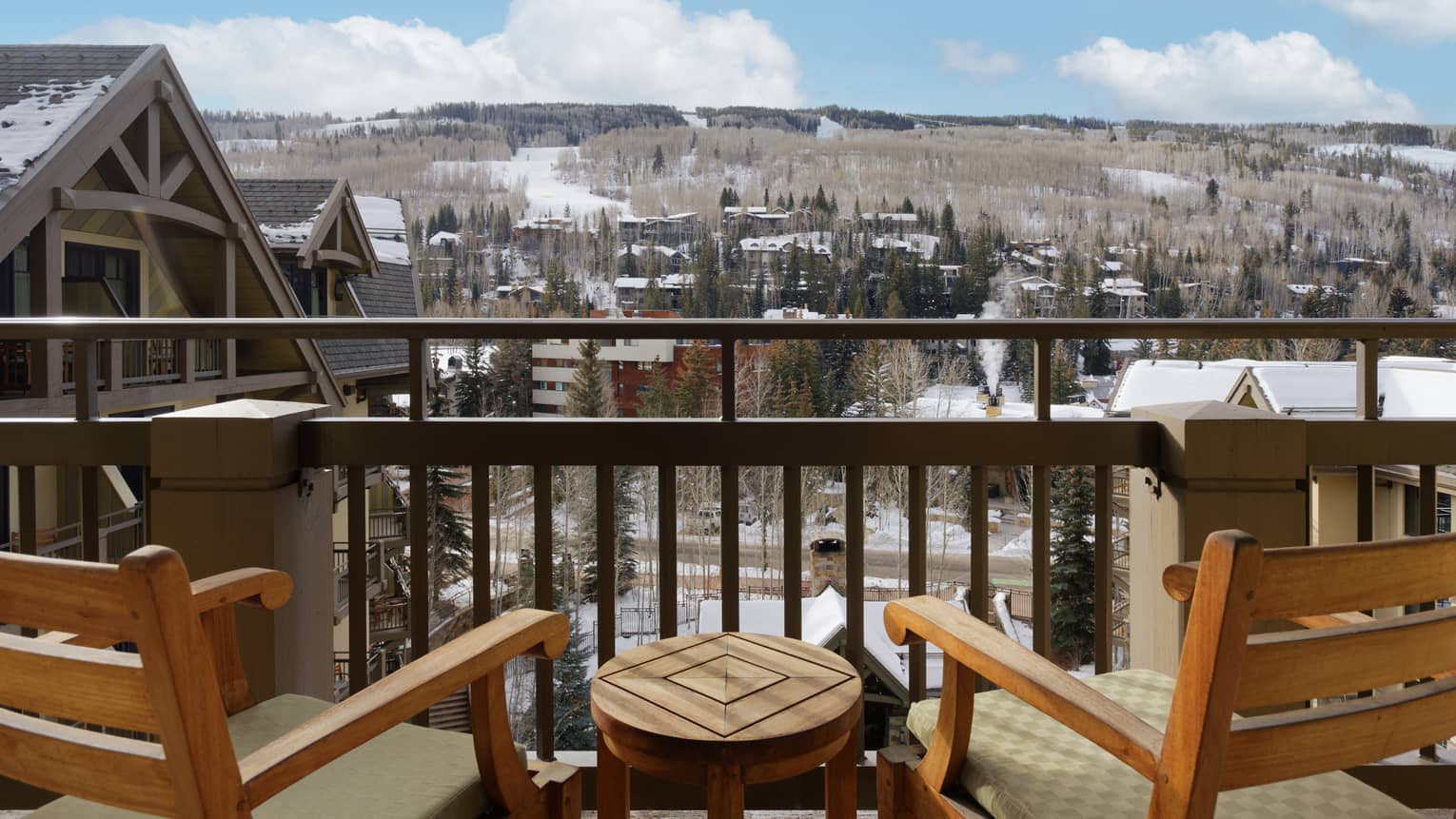 Mountain-view terrace with two wooden chairs and small table