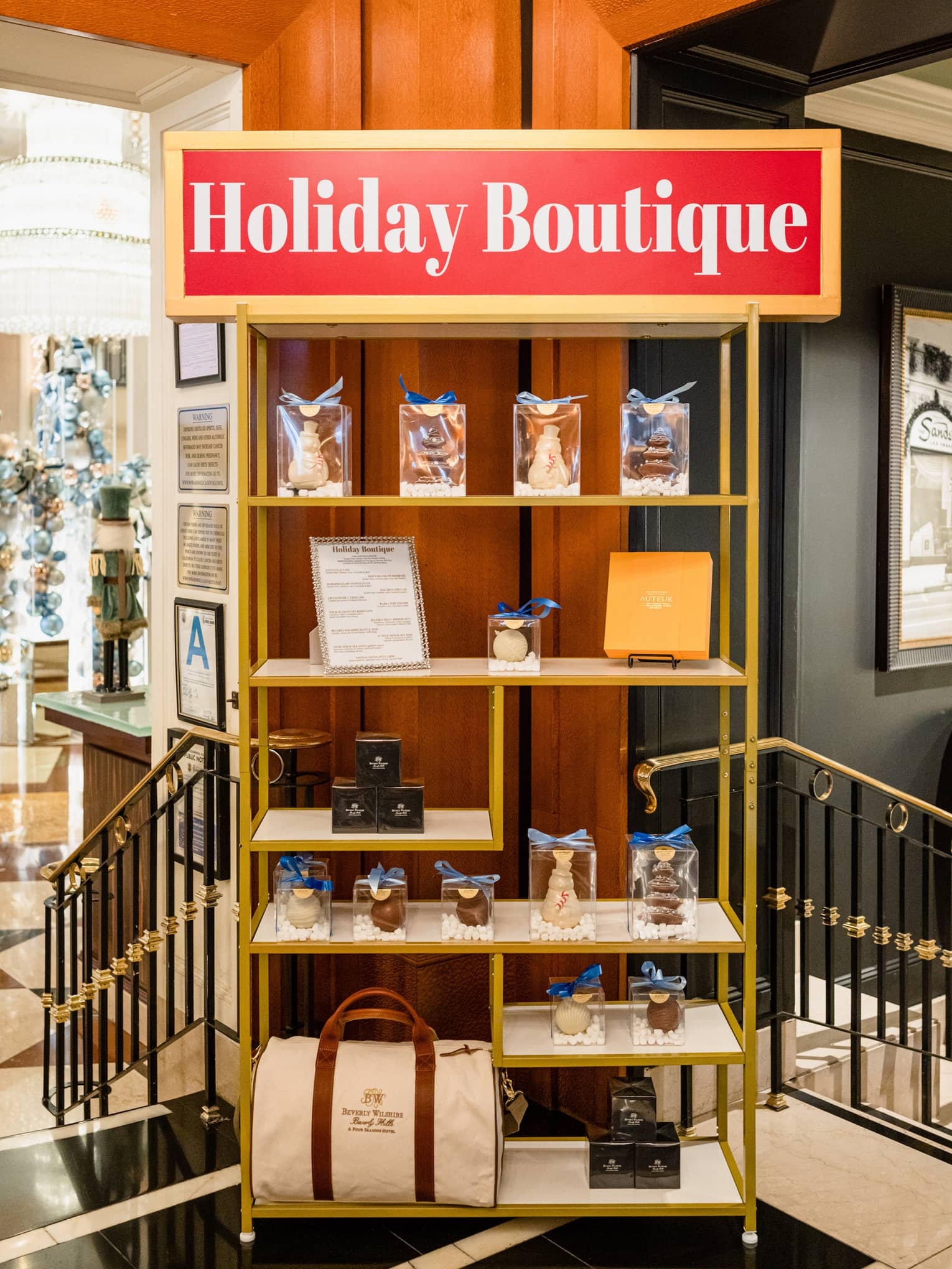 Gold retail shelf with a red sign that reads "Holiday Boutique" in white letters