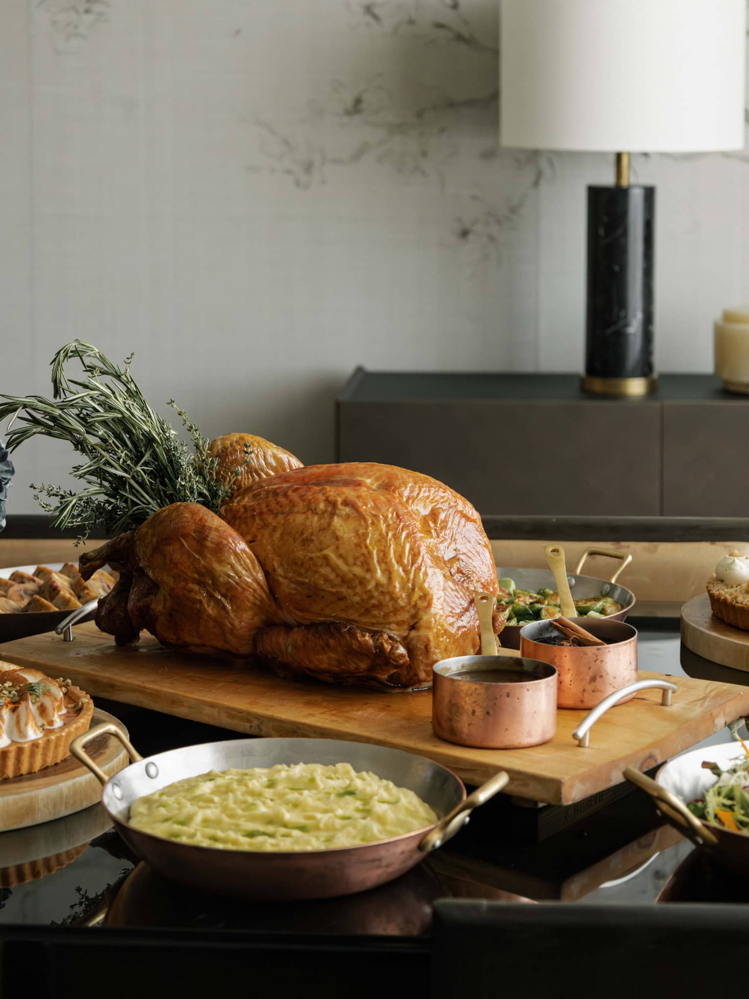 A whole roast turkey and sides set out on a dining table