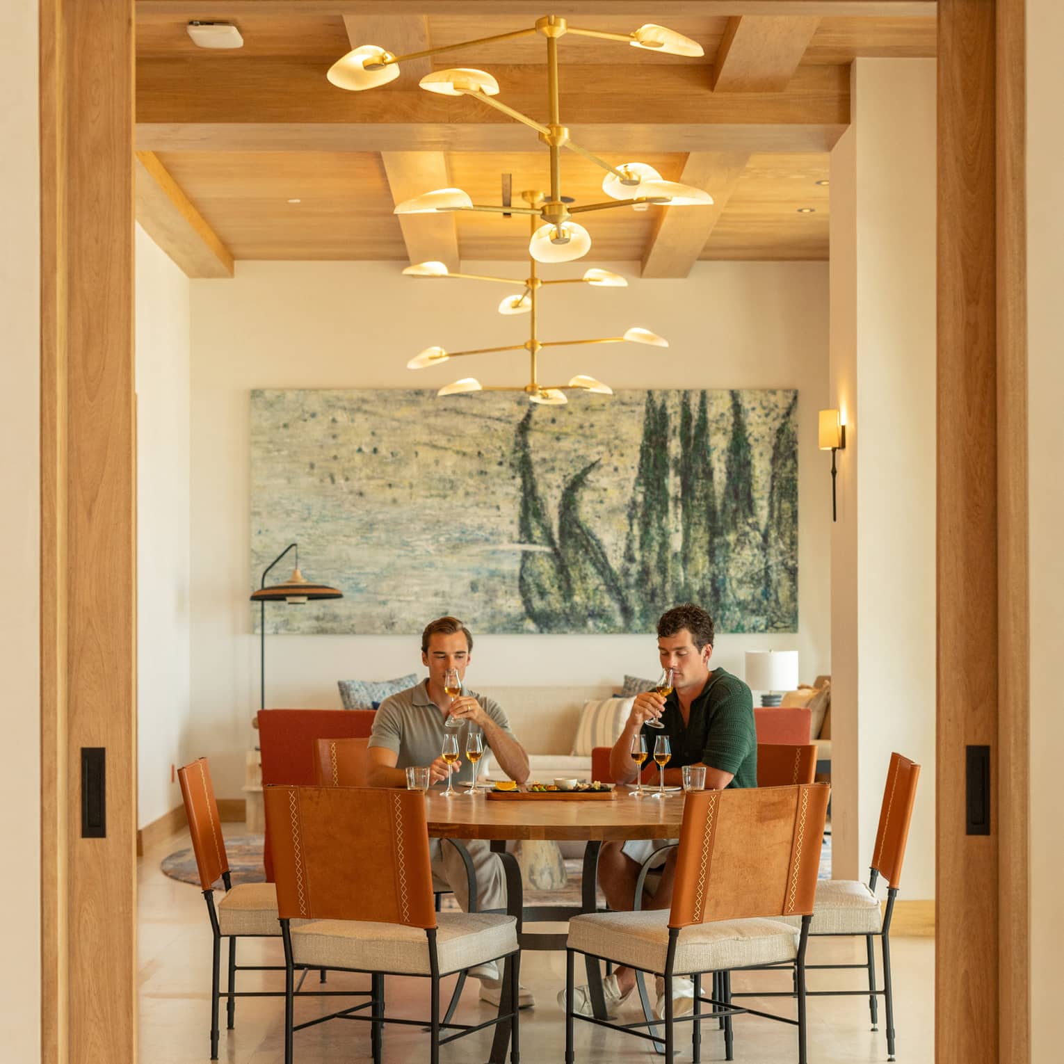 Two people sit at round table in dining room, tasting agave
