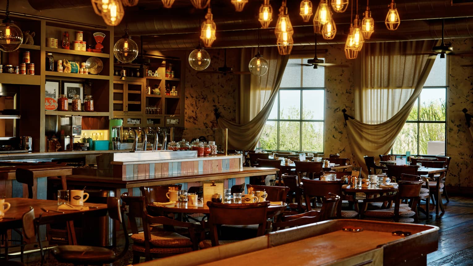 Proof restaurant with shuffleboard table and hanging lights, at Four Seasons Resort Scottsdale