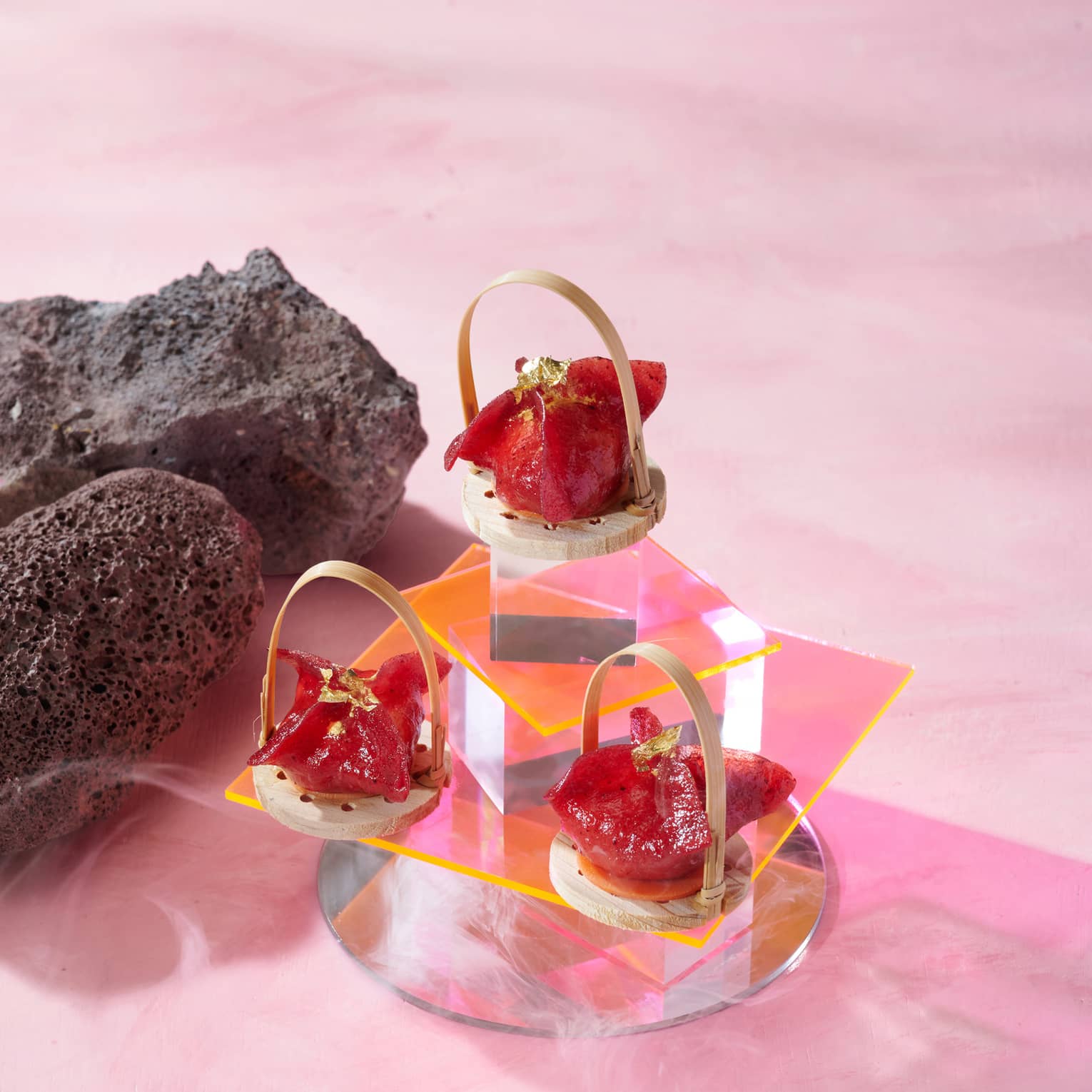 Tiered glass display of small red-hued dumplings