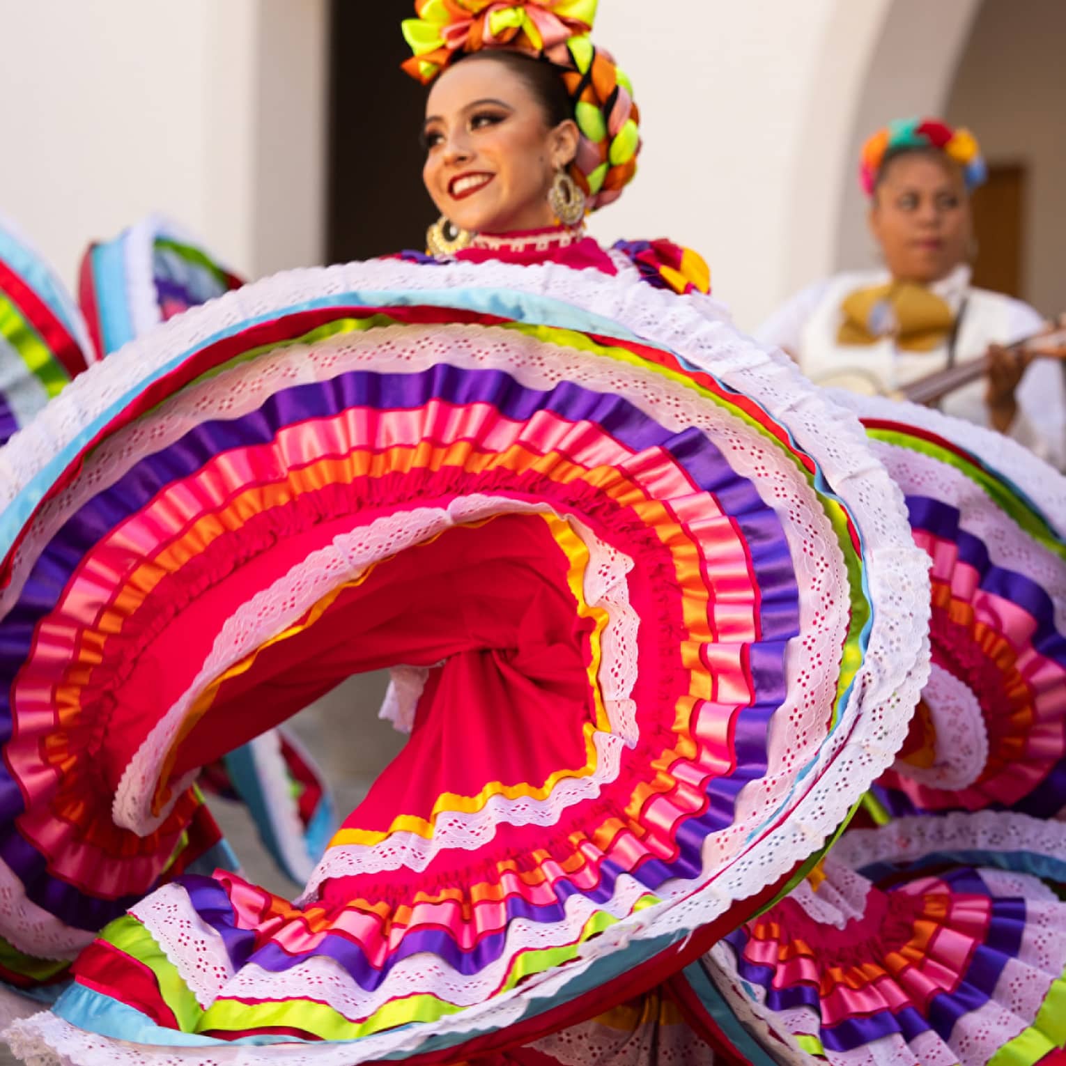 Woman dances wearing traditional Mexican dress