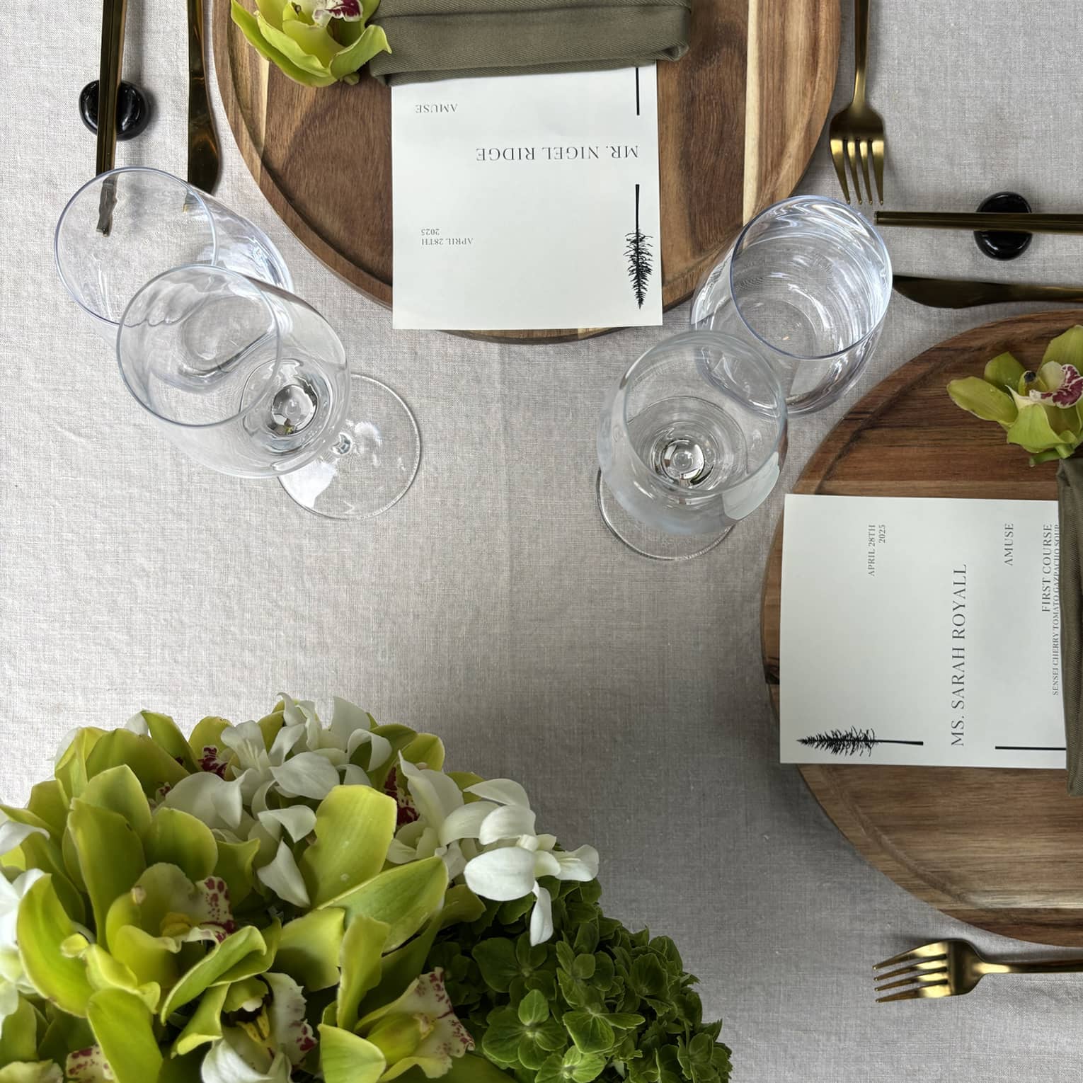 Table setting for two with green floral arrangement