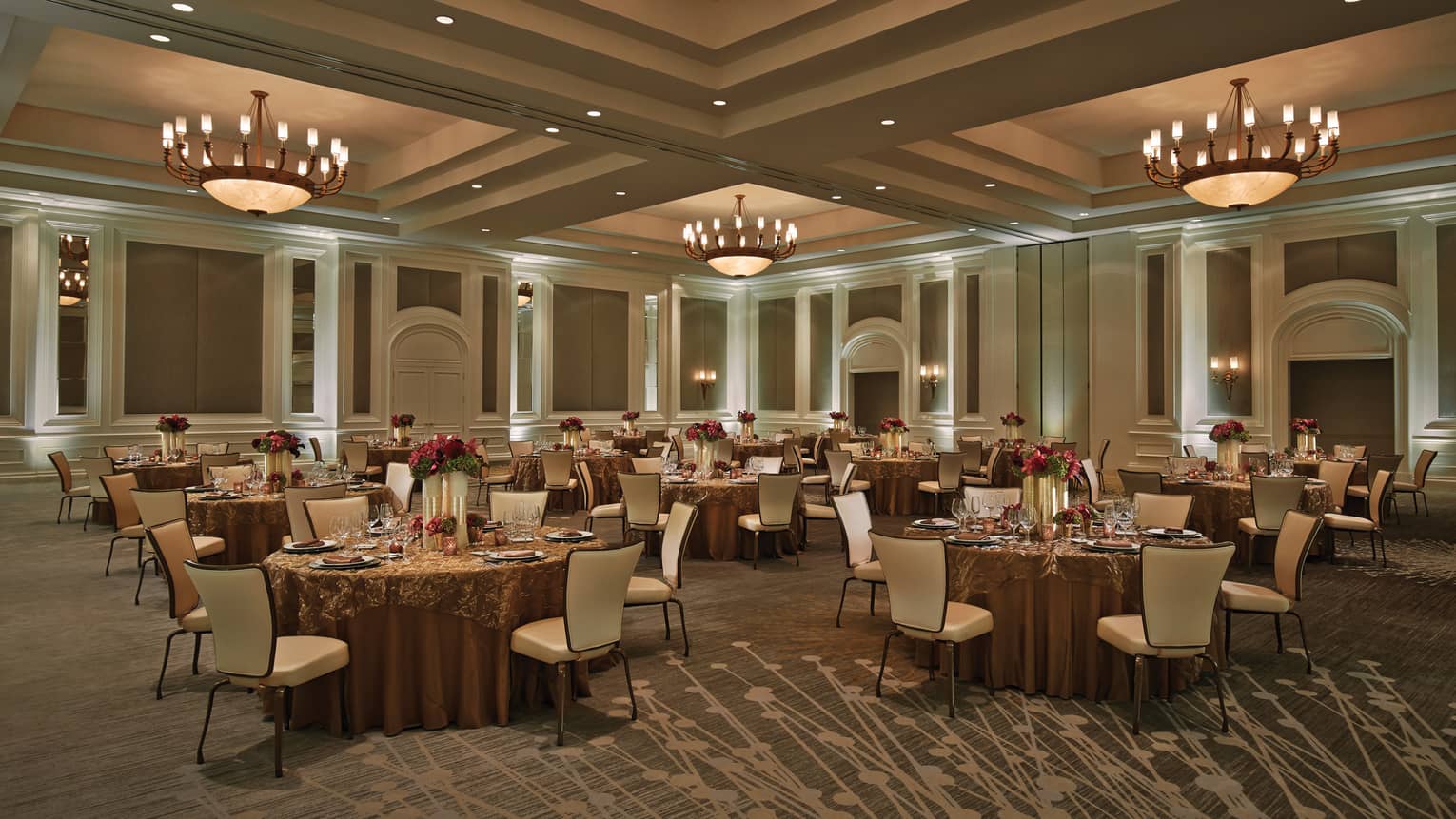 Small round dining tables under large dome lights in Acacia Ballroom