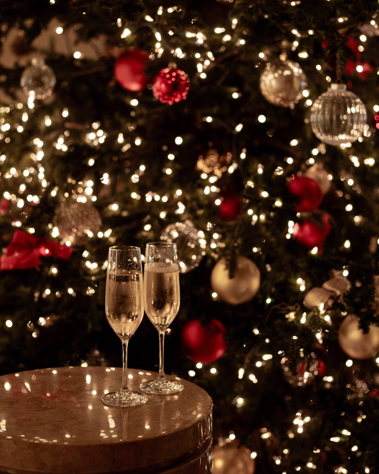 Joyous champagne toast with festive lights for Tokyo Christmas and New Year’s Eve celebrations.