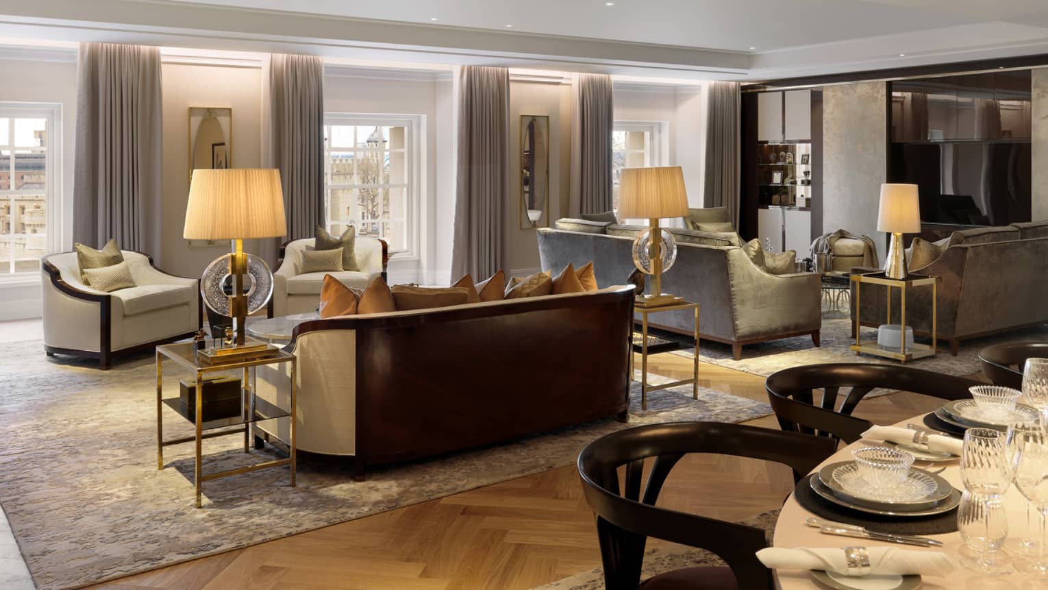 Large neutral living room with two seating vignettes flanked by lamps on side tables