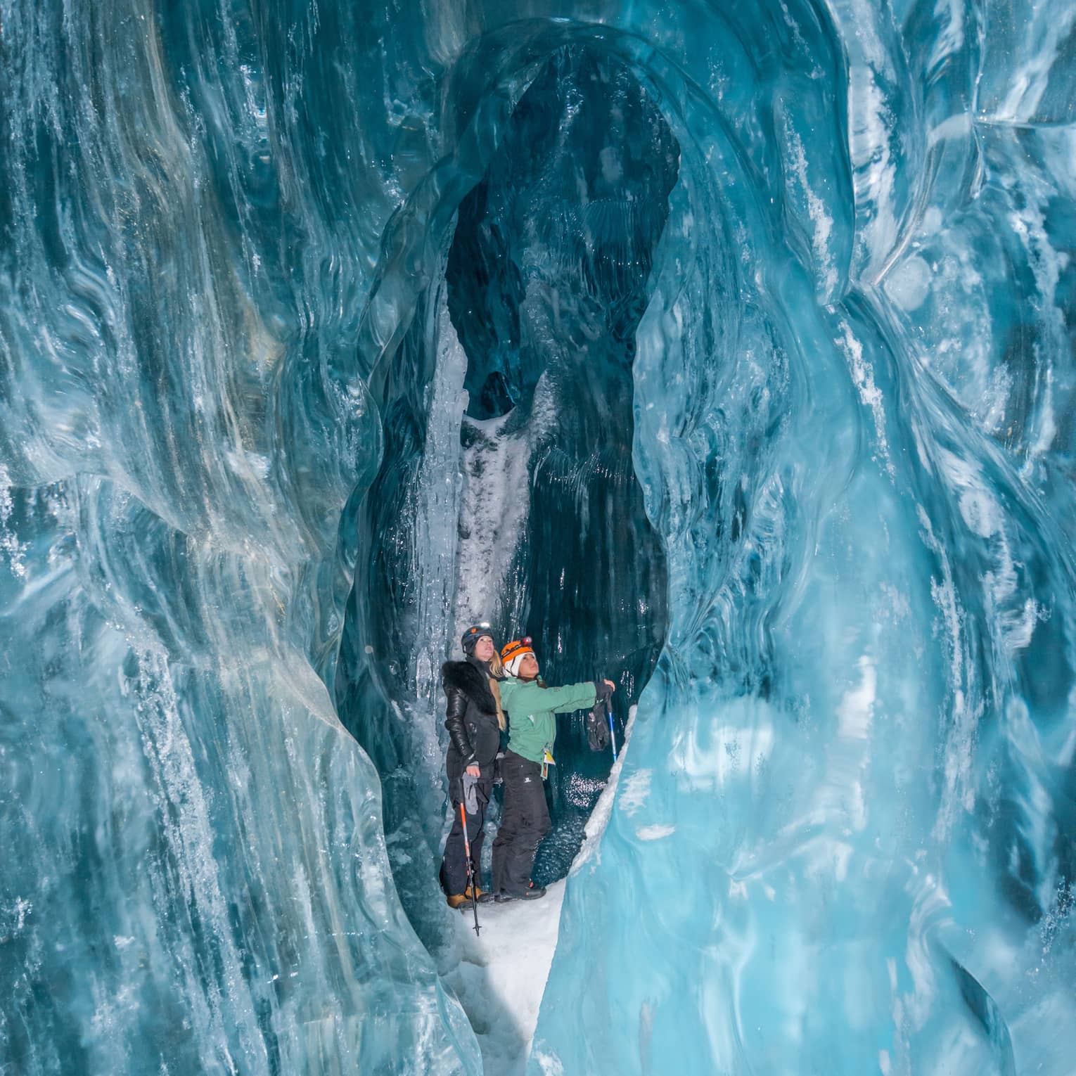 Two people walking in an ice cave in Whistler