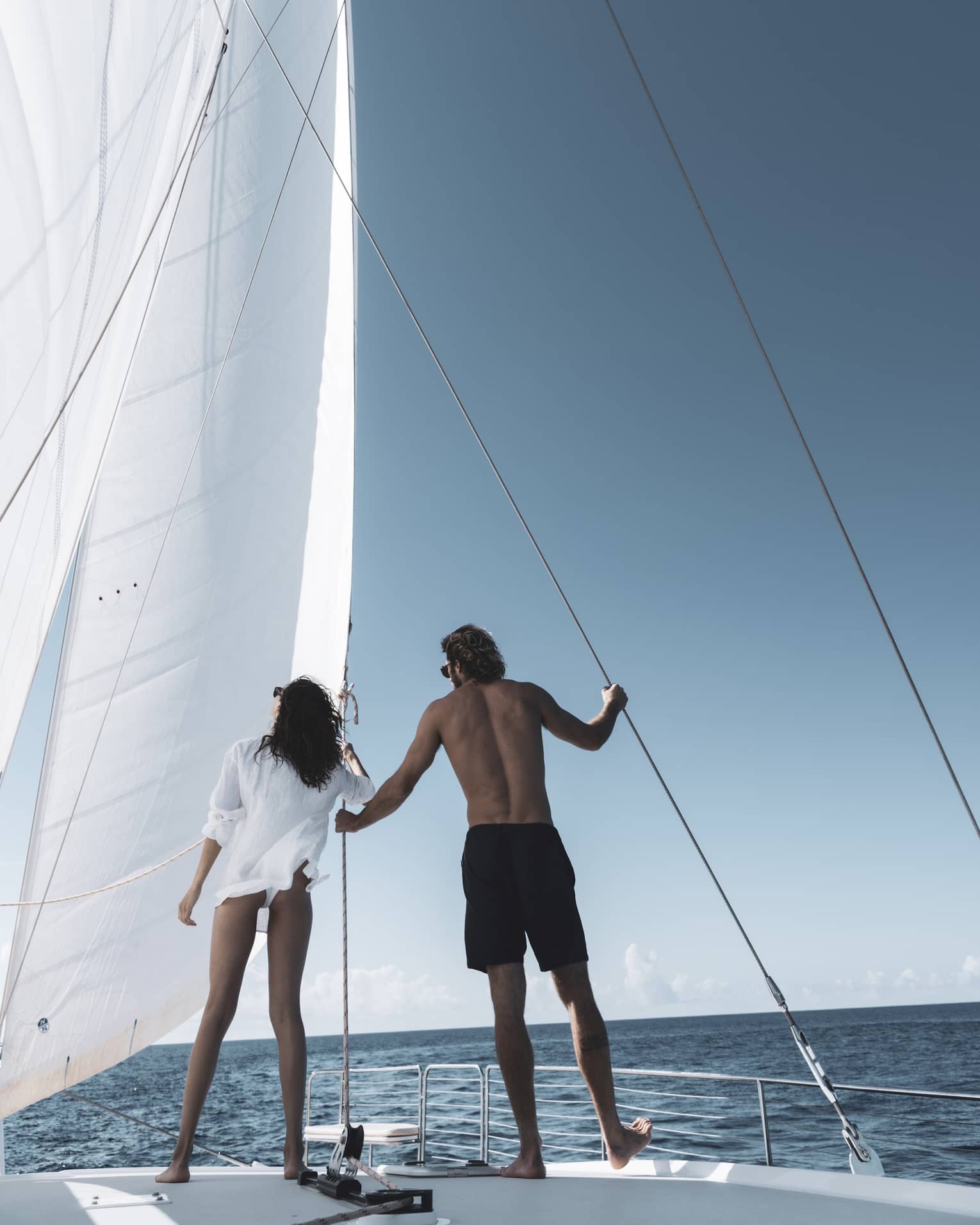 Two people stand on luxury catamaran
