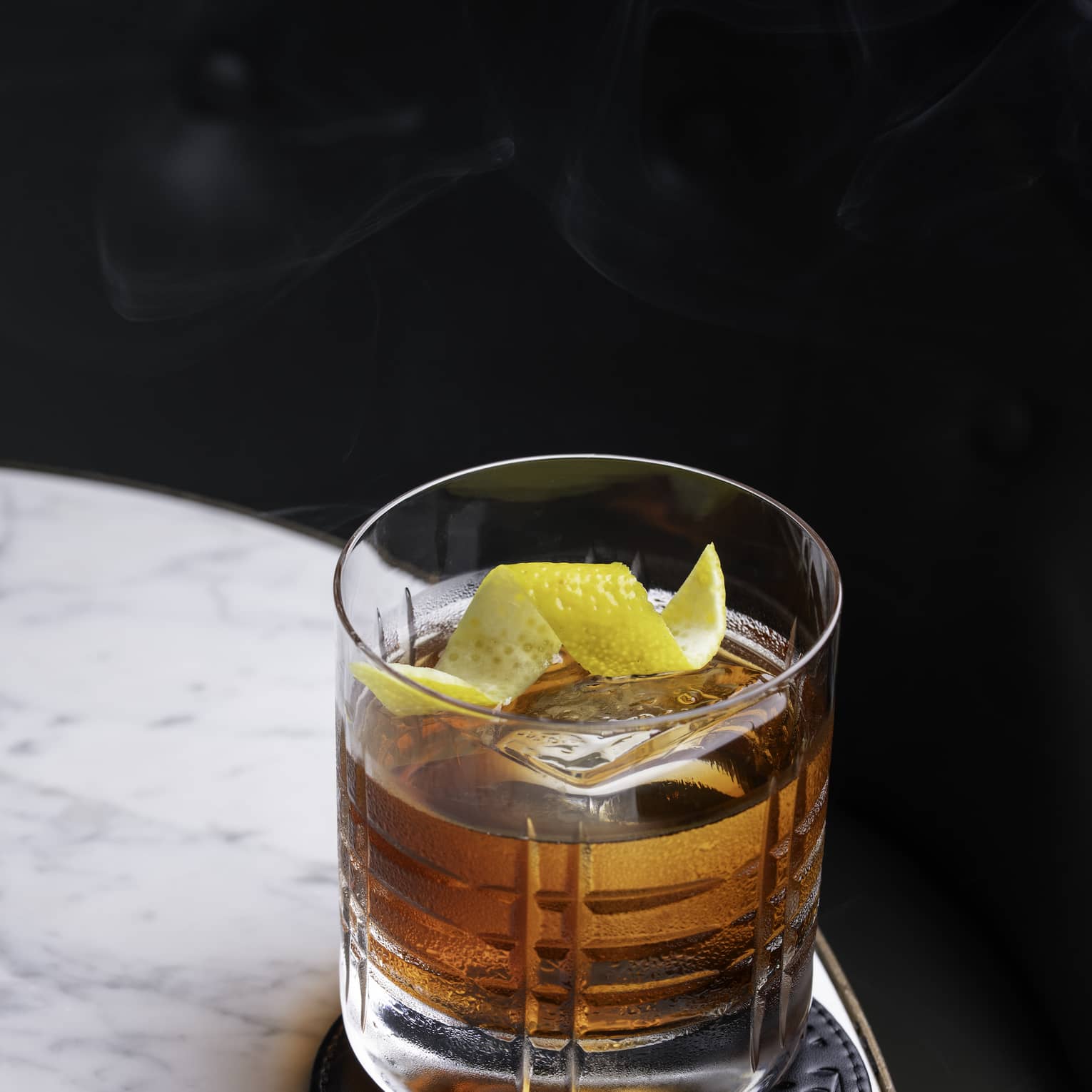 Old Fashioned cocktail on a marble table