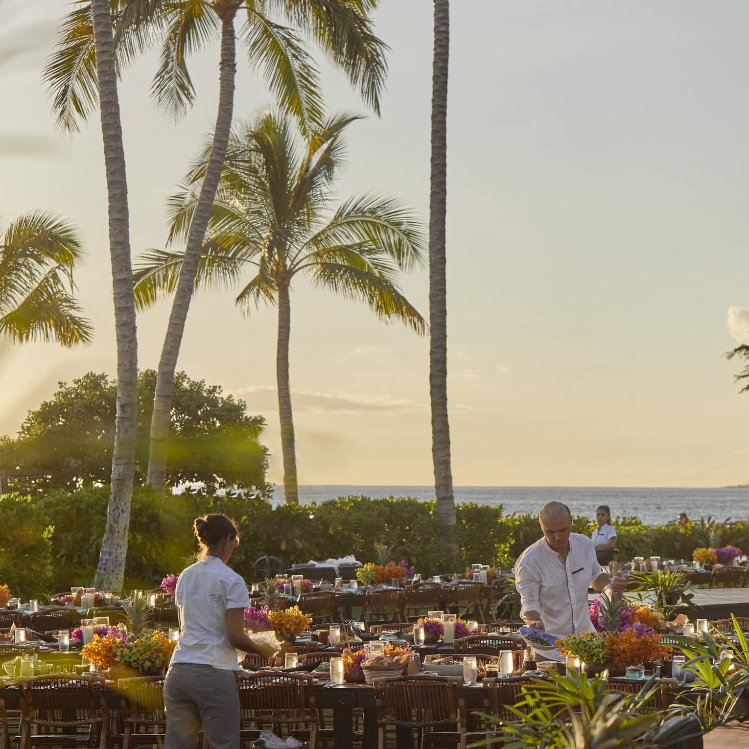 Four Seasons staff setting tables outside of Four Seasons Hawaii, Oahu at Ko Olinaat a Luau Dinner