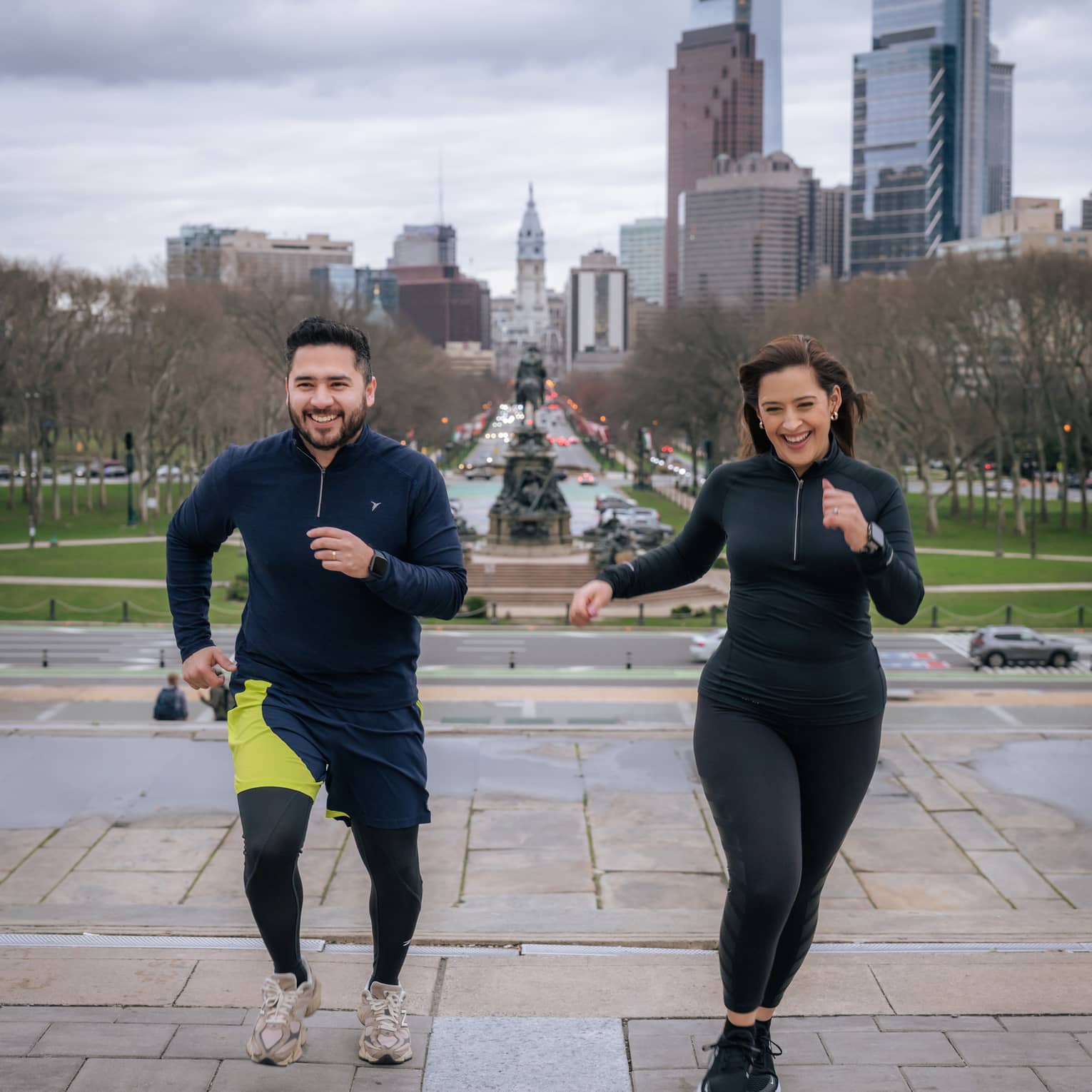 Two guests wearing exercise clothes and running outside.