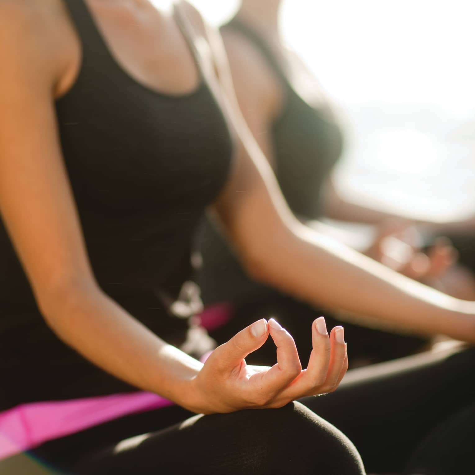Two women sitting in a yoga pose.