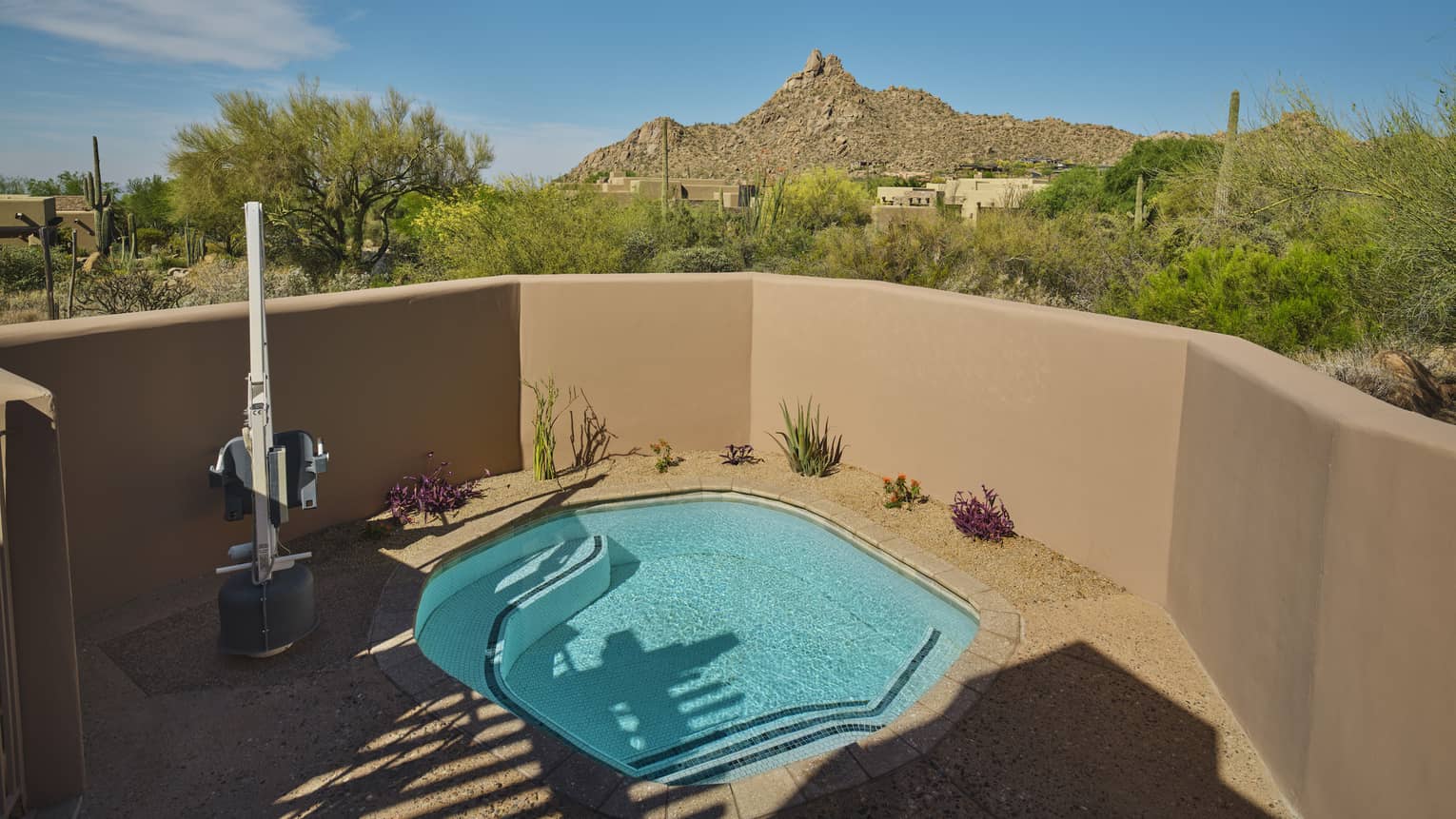 Private plunge pool with a mobility accessible feature, surrounded by desert views