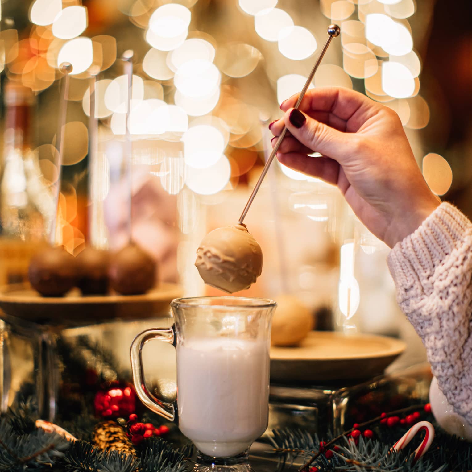 A person making hot chocolate in front of many lights.