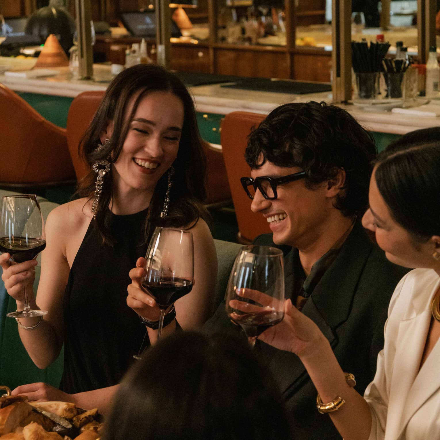 People enjoying a meal and wine in an indoor dining space