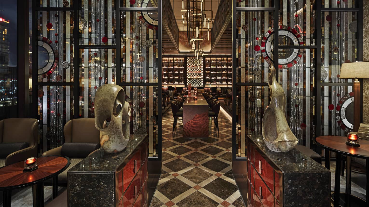 Entryway to VIRTU with sculptures, low lighting, red and black accents