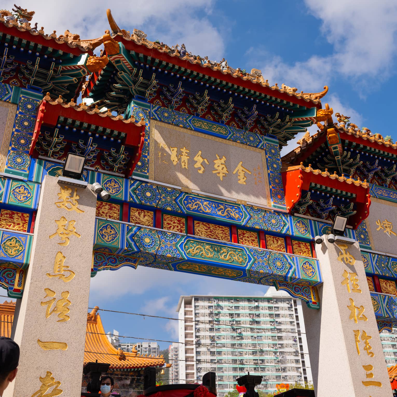 Ornate entrance to a temple in Hong Kong, Wong Tai Sin, with blue and red colours and gold writing