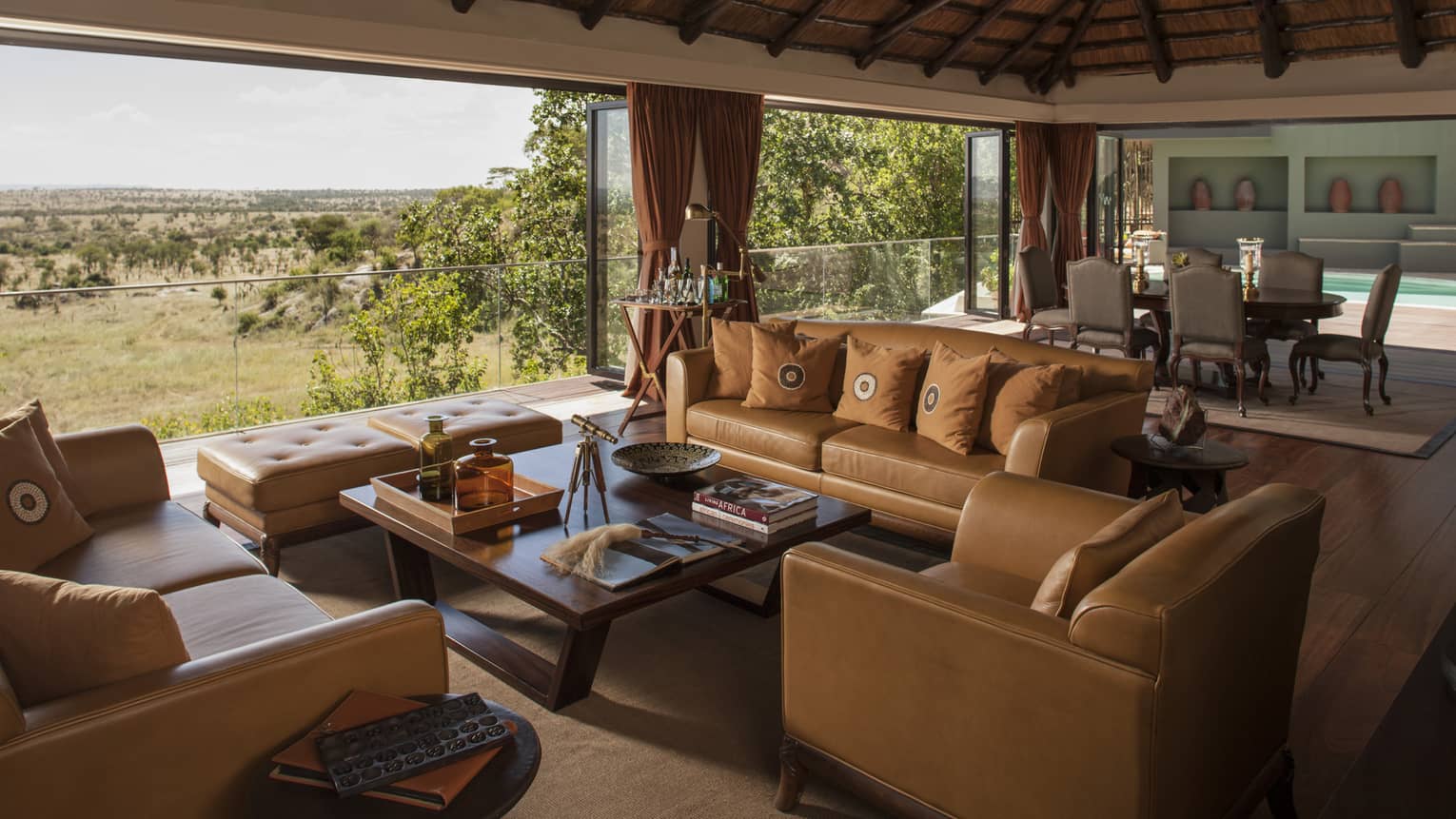 Presidential Villa tan leather sofas, chairs around table, large dining room, open wall