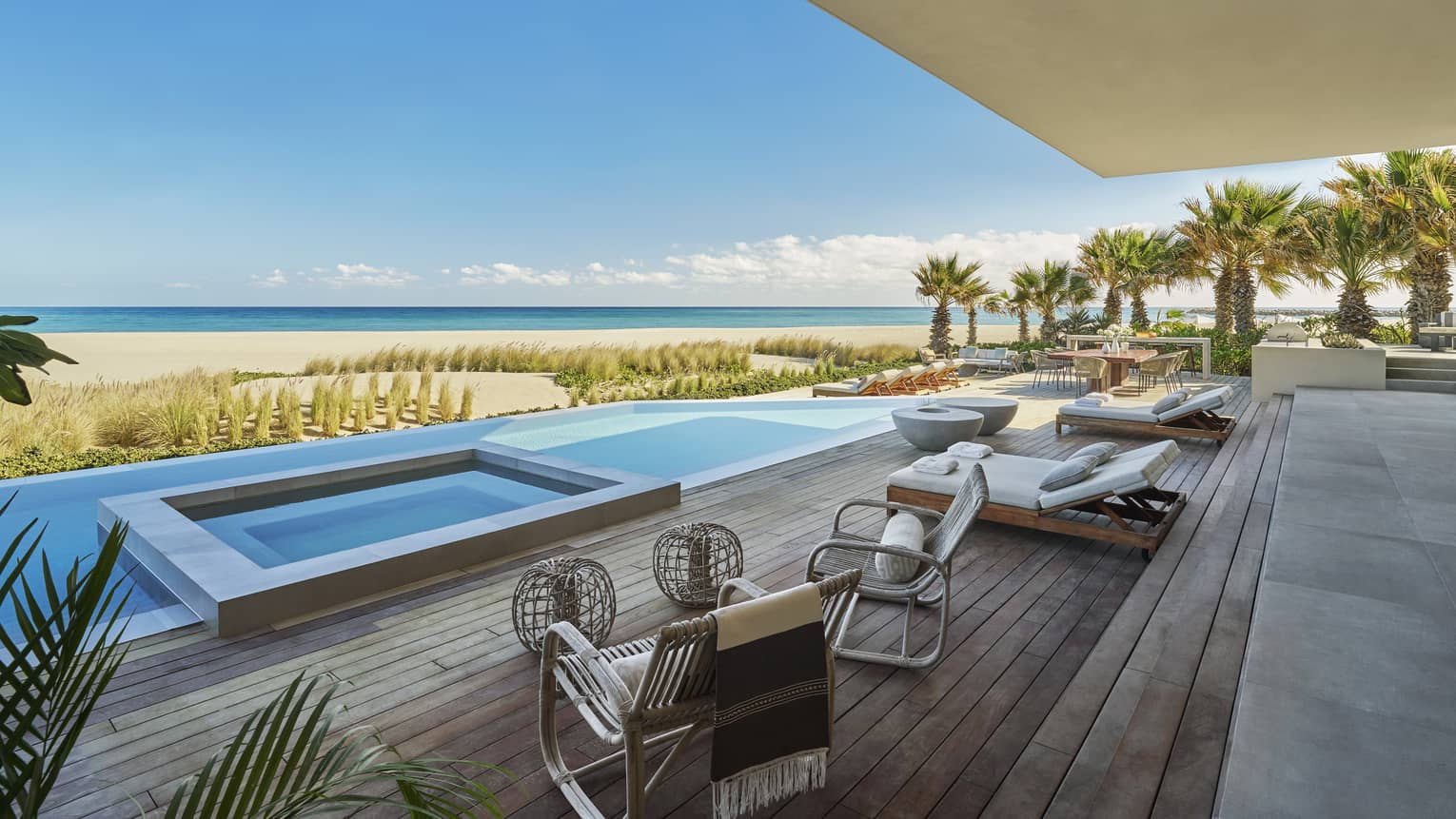 Private pool terrace with high-end lounge beds and chairs, and view of beach and sea, at Four Seasons Resort and Residences Los Cabos