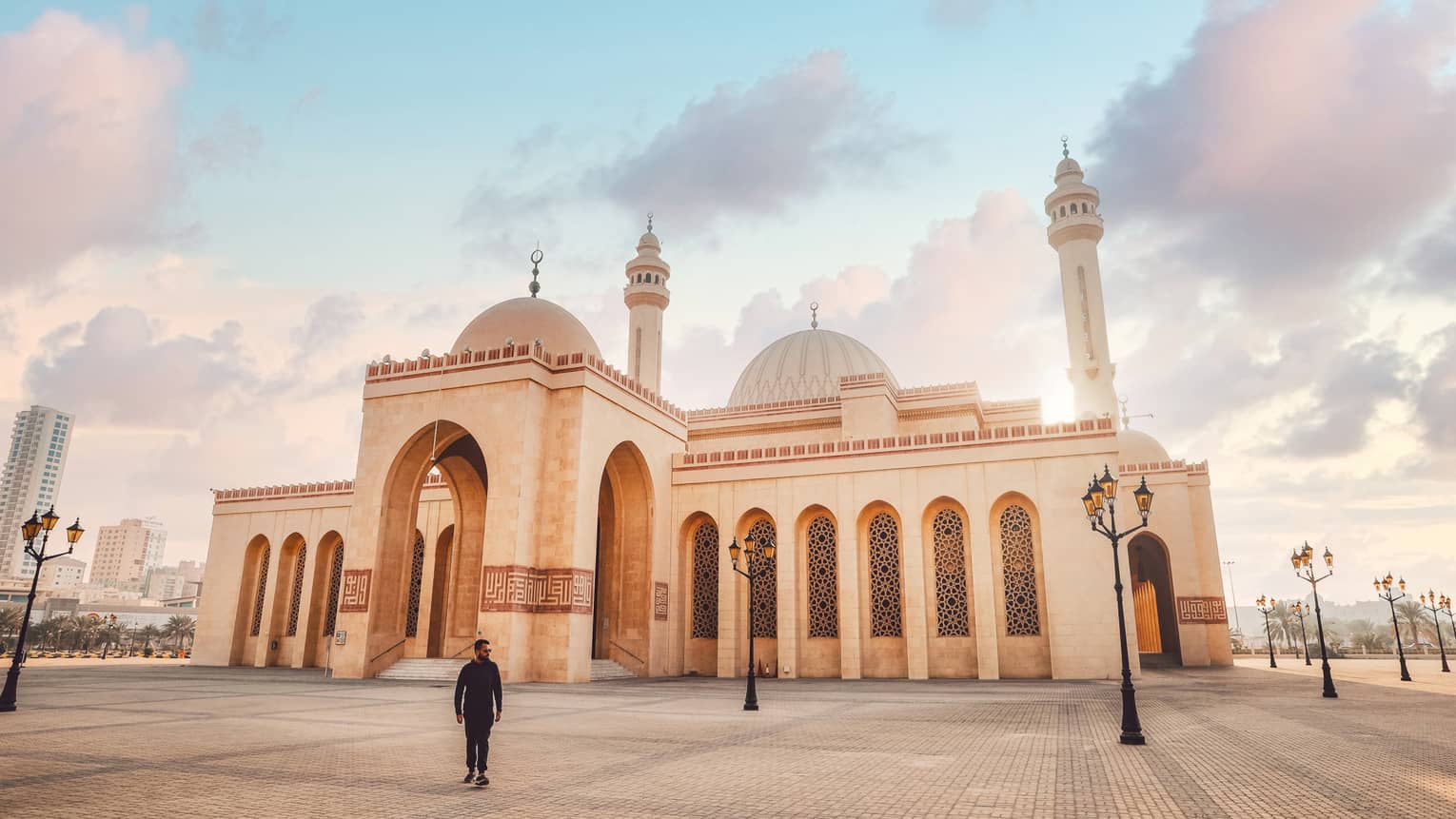A large tan mosque with several pillars.