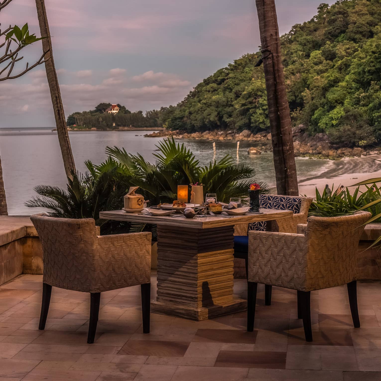 A patio with a table and chairs overlooking the ocean