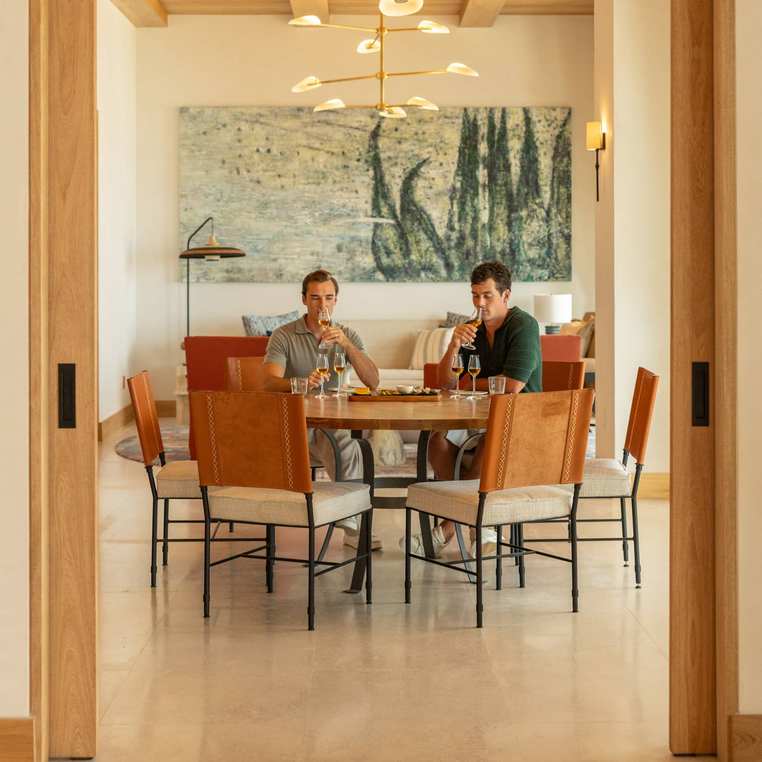 Two people sit at round table in dining room, tasting agave