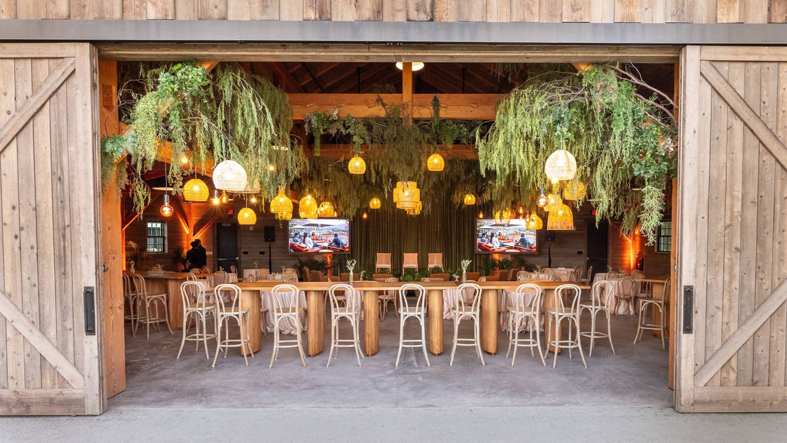 A venue with barn doors and plants hanging on the ceiling
